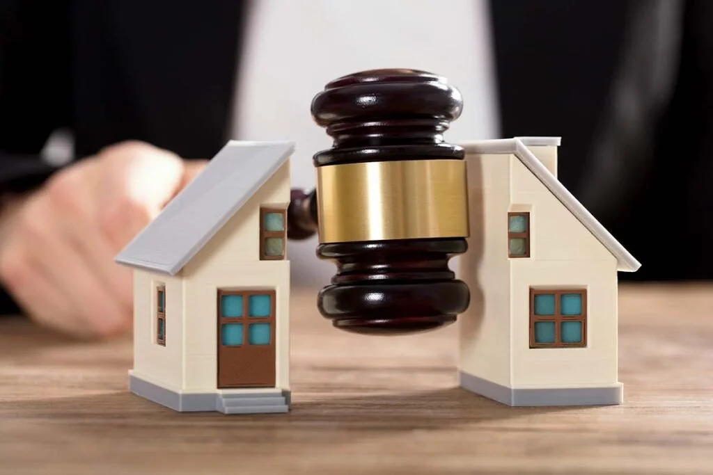 Miniature houses with a gavel in between, symbolizing real estate or legal decision-making in property.