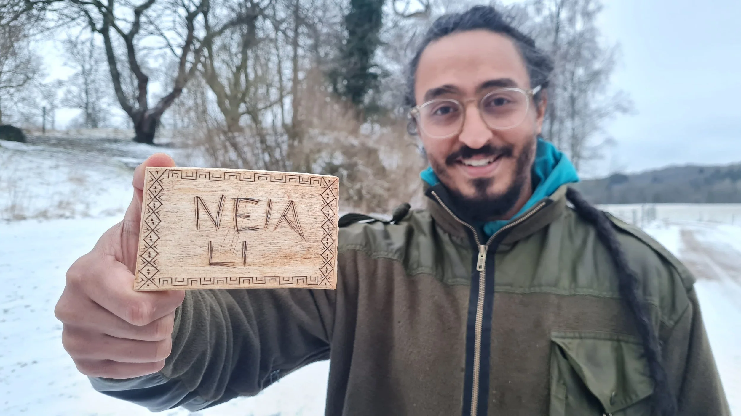 jag och en kolrosad namnskylt