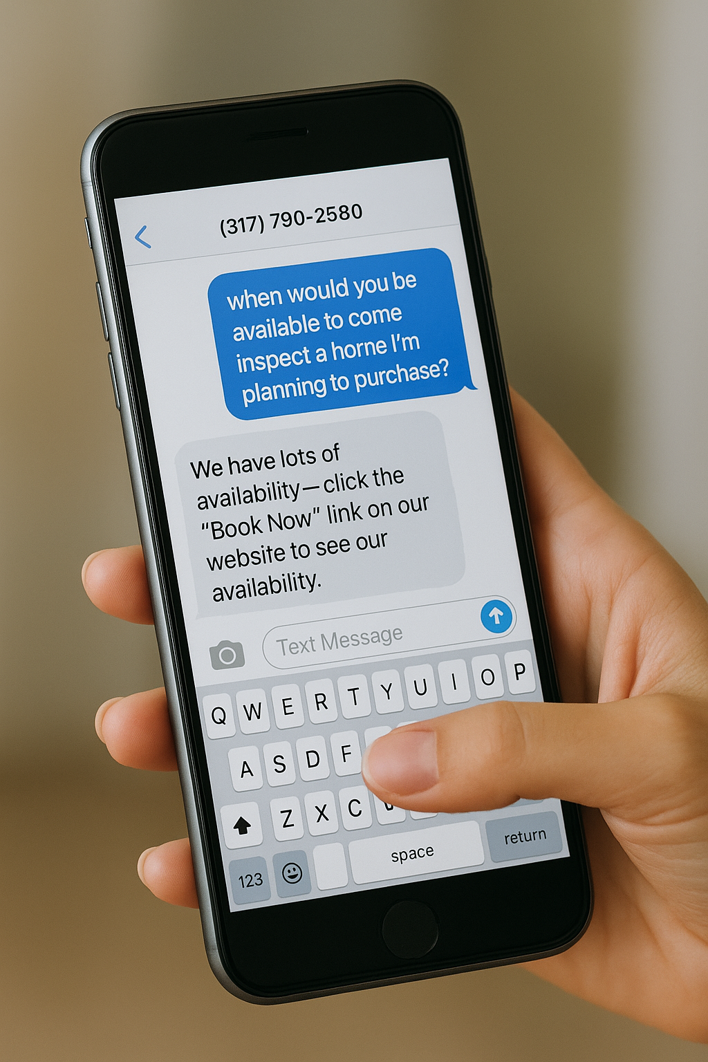 A person holding a smartphone displaying a conversation about scheduling an inspection for a home or property.
