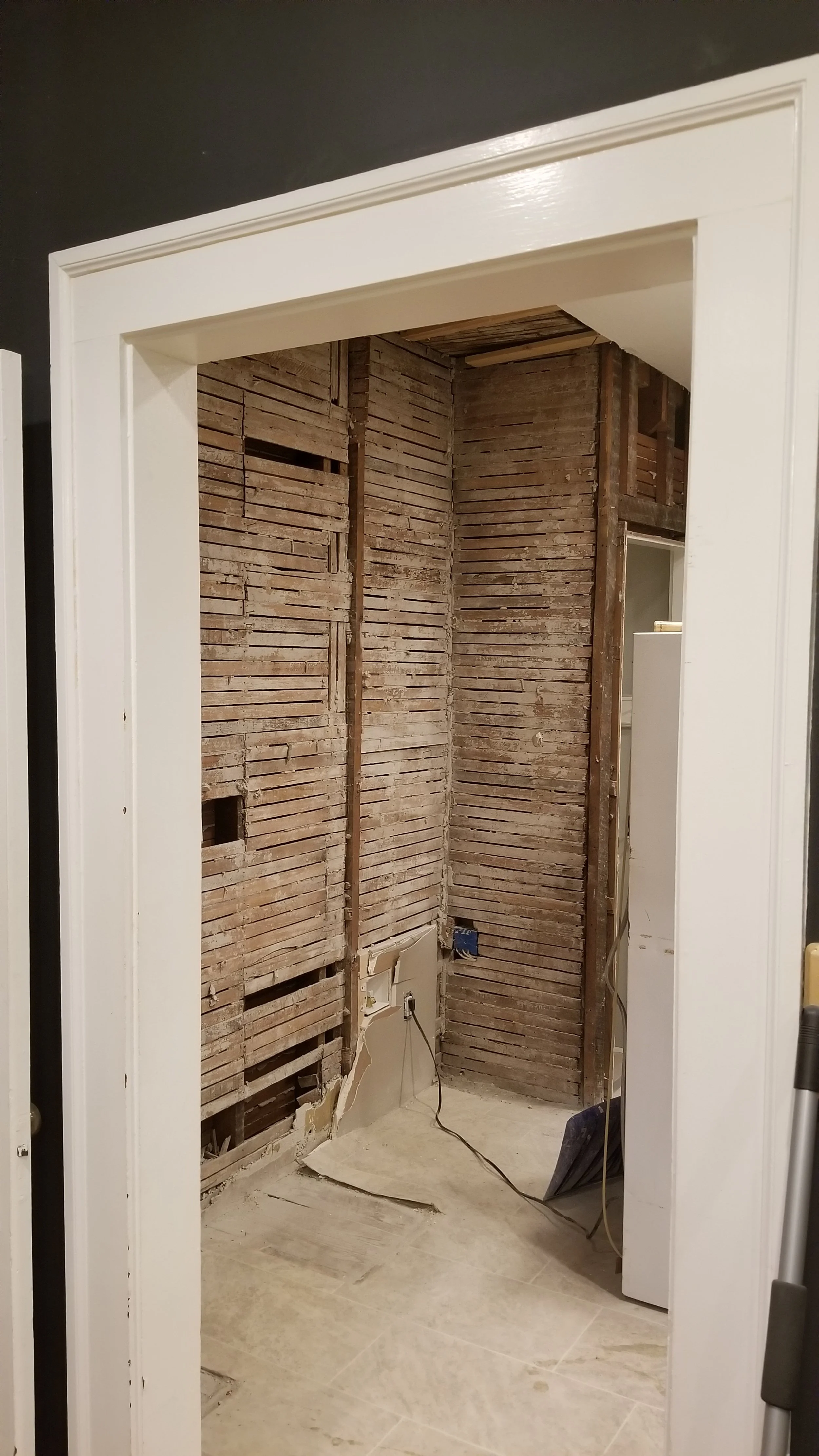 Contemporary home interior with doorway showing bathroom renovation in progress, exposing exposed wooden wall framing and electrical outlets.  Plan for the future home you want prior to starting construction.