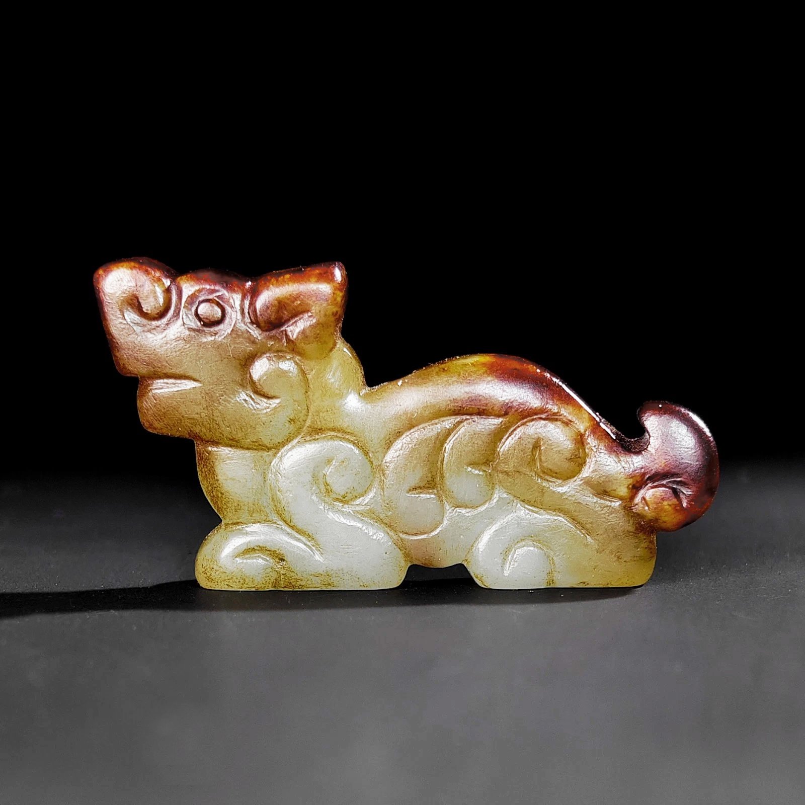 A Chinese Celadon and Russet Jade Tiger Pendant