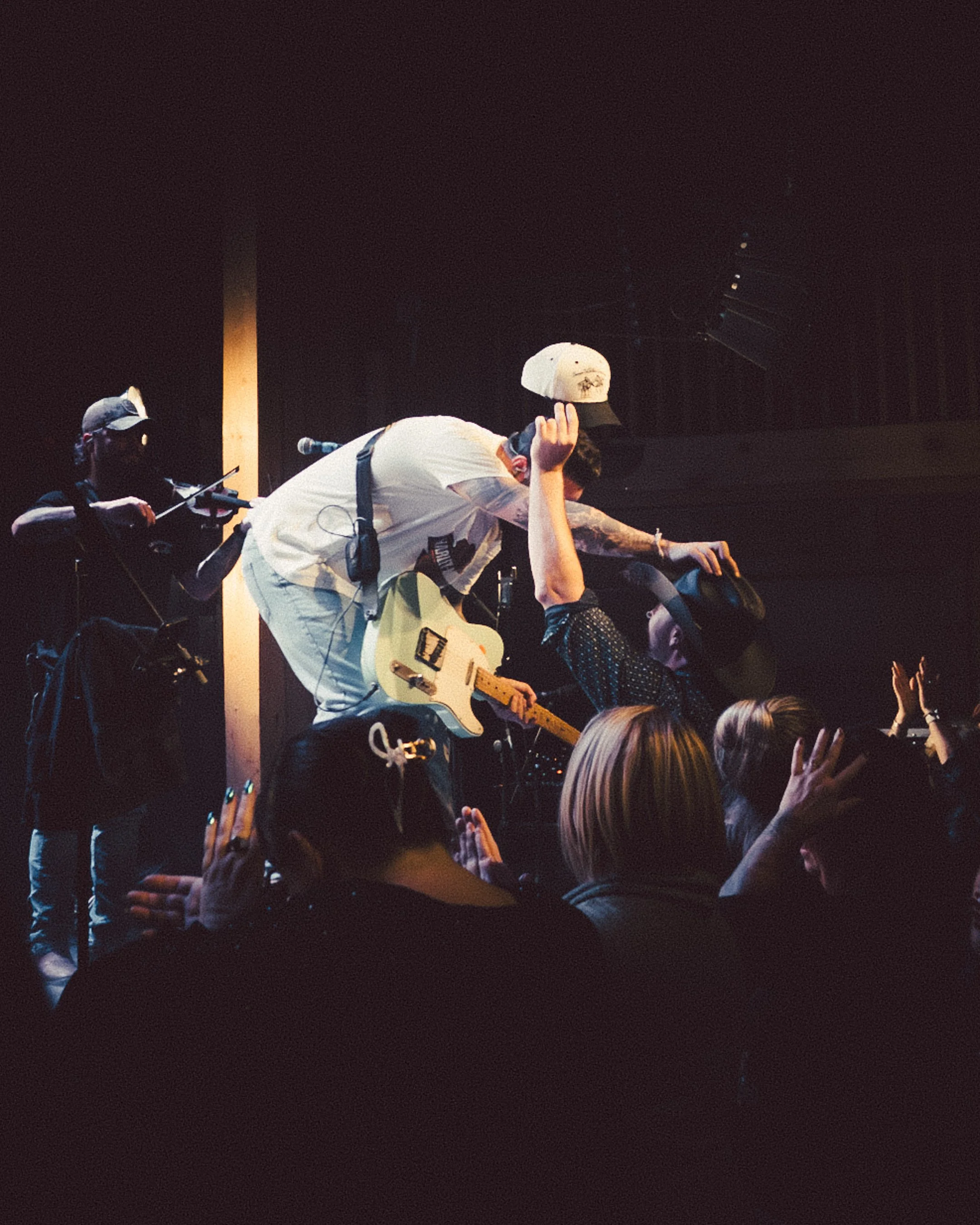 Musiciens sur scène lors d'un concert, interaction avec le public.