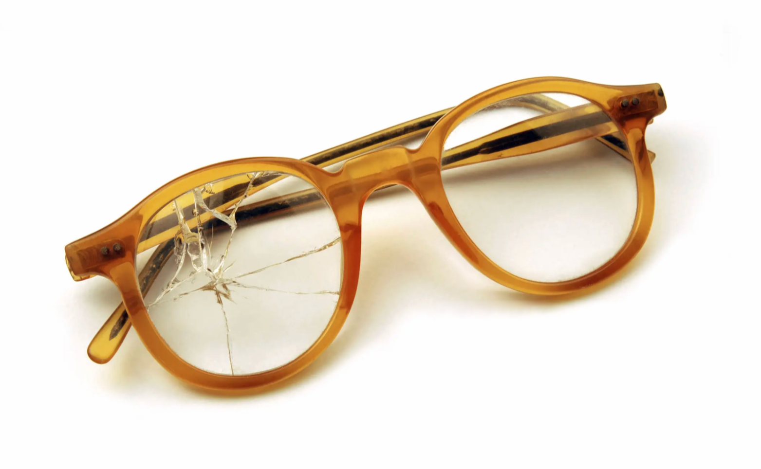 Broken orange eyeglasses with cracked lenses on a white background.