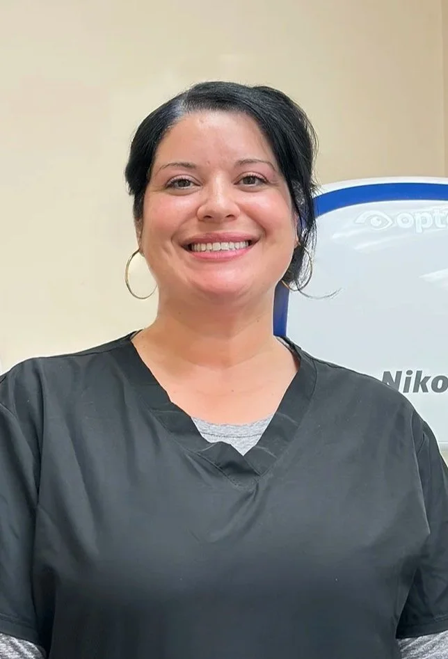 light-skinned woman with dark hair in grey scrubs
