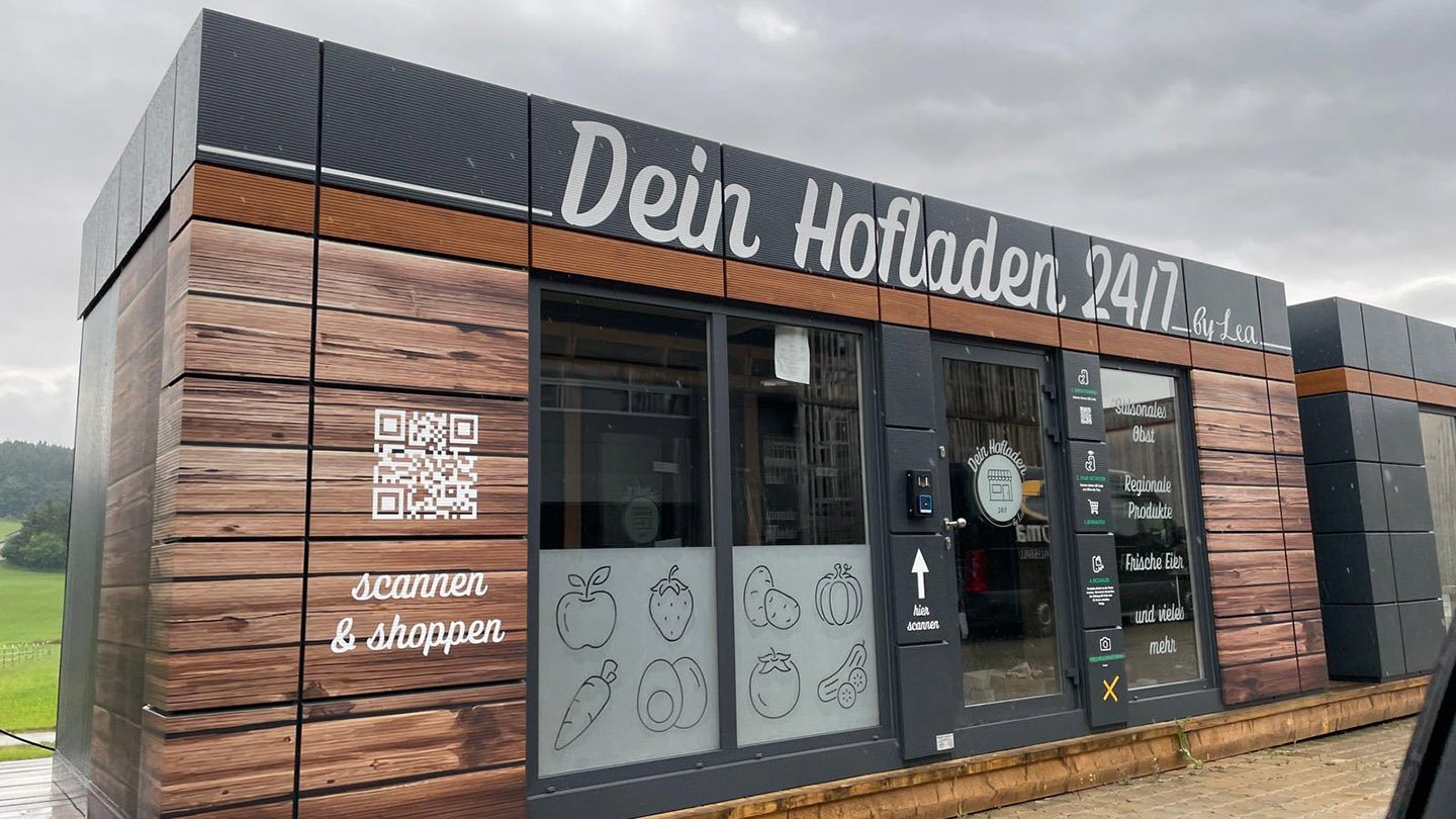 Ein moderner Supermarkt mit Holzverkleidung und digitalen Zahlenterminals.