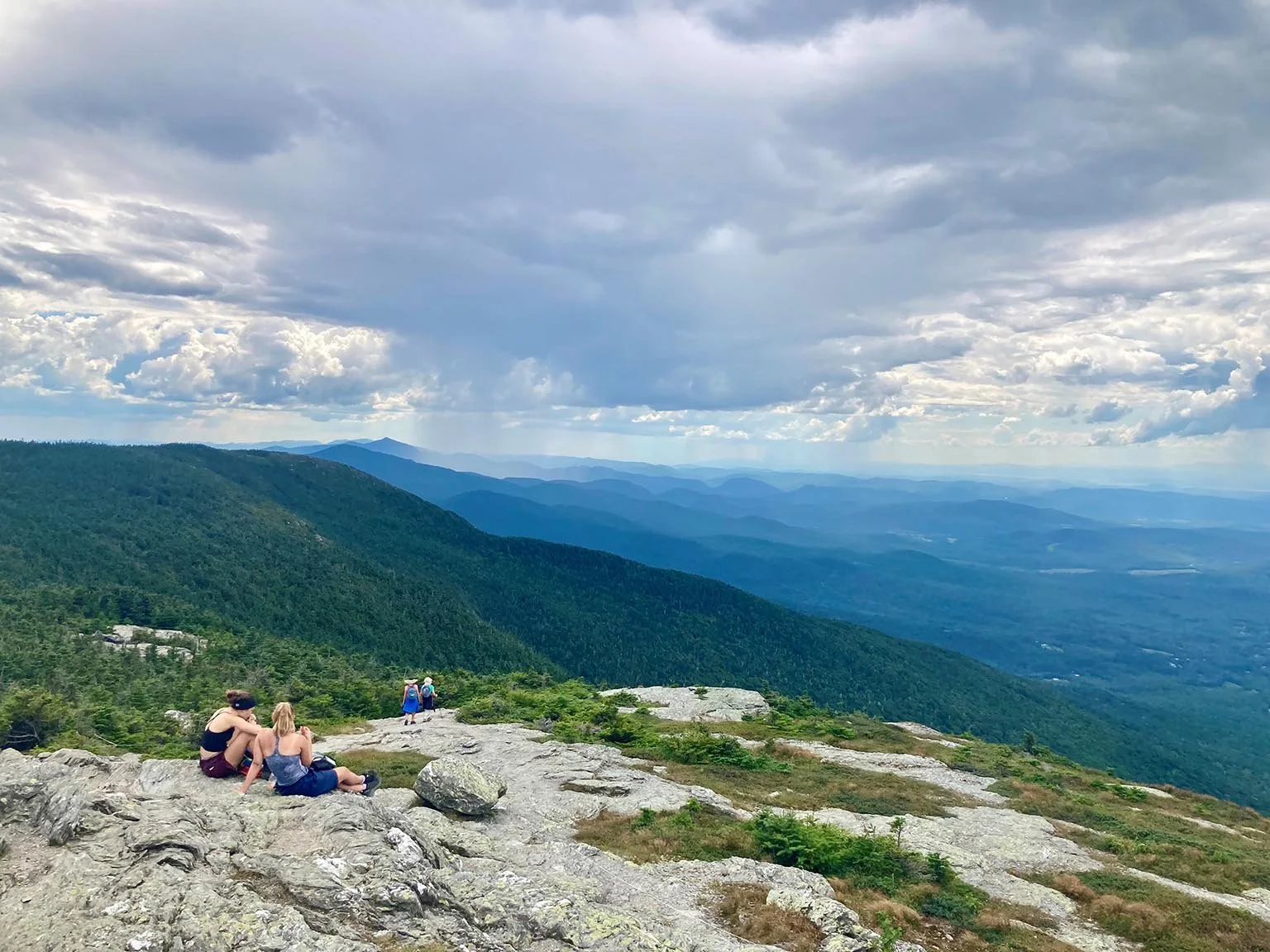 Hikers rest on Mt Mansfield in Vermont looking out over the trees. (Copy) (Copy) (Copy)