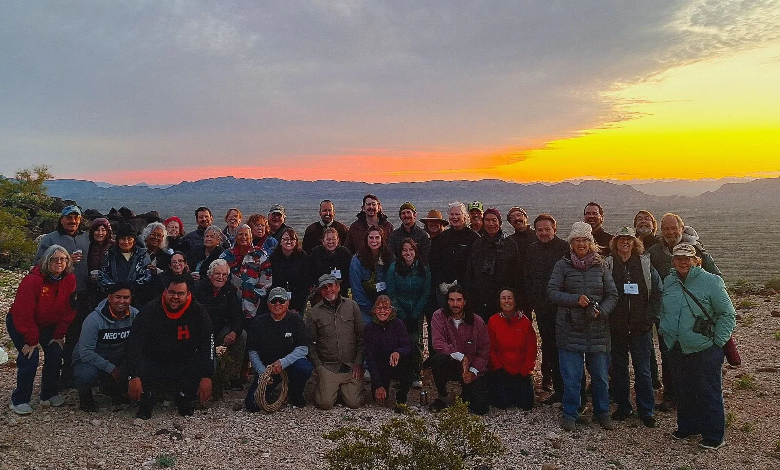 Sonoran Desert Biosphere Region participants posing for group photo while glowing sunset behind them.