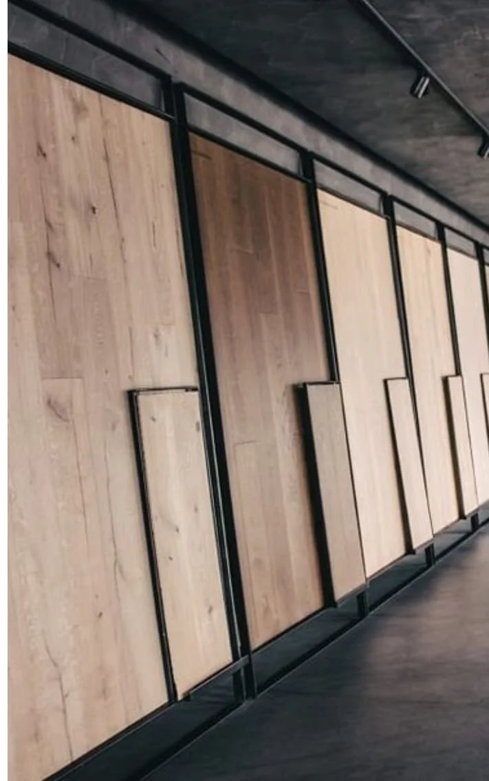 Paneles de madera montados en una estructura metálica negra en una pared interior.