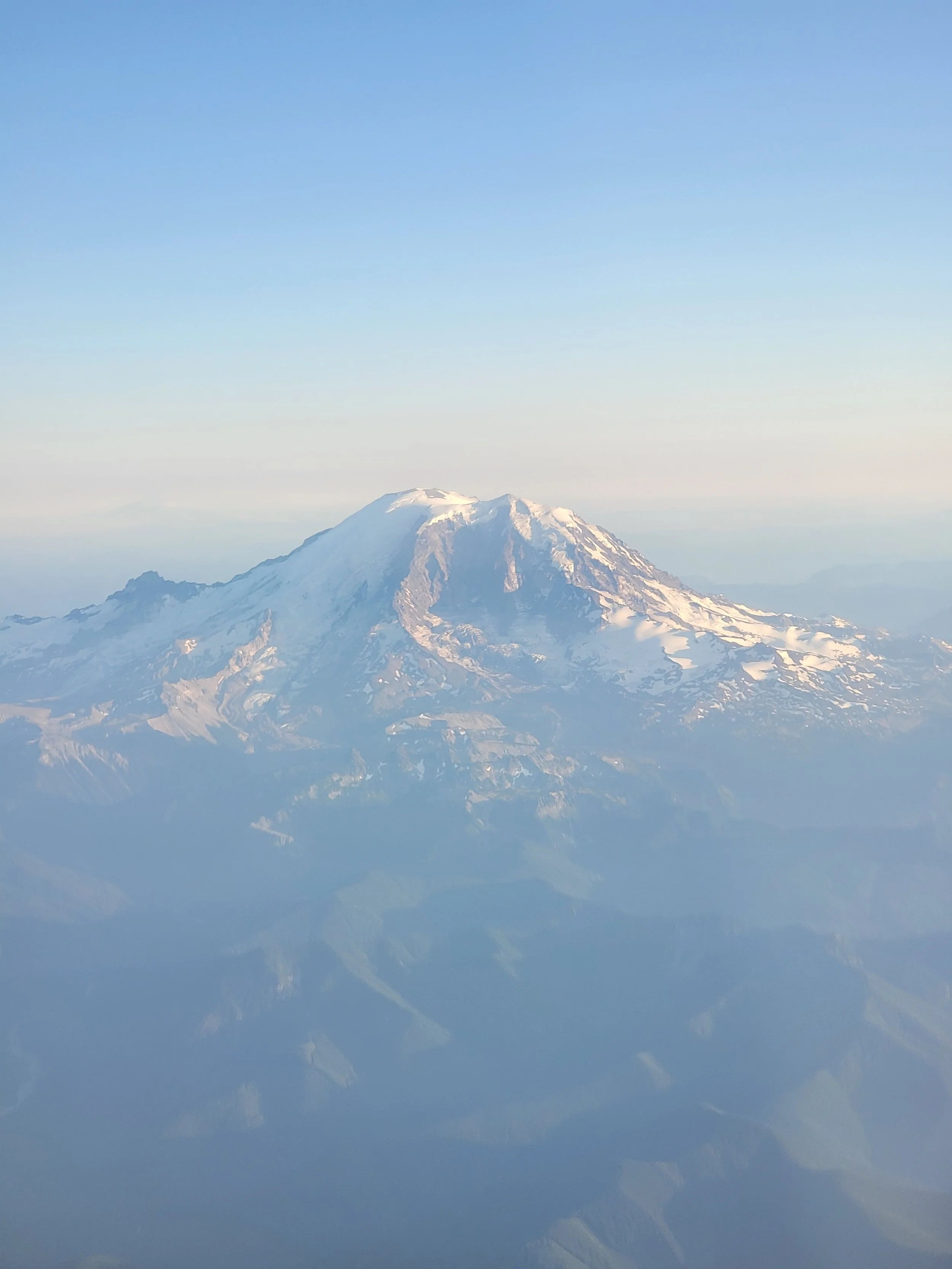 A snow-capped mountain under a clear blue sky.