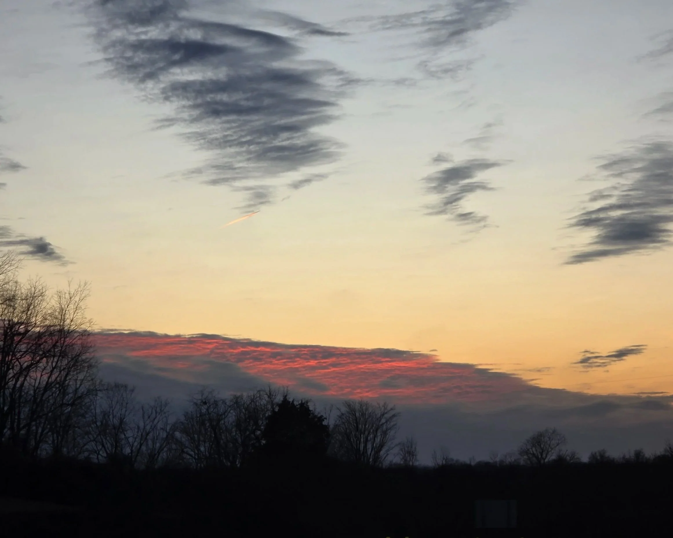 A sunset that looks like a hot pink mountain, with charcoal clouds above like scribbles.