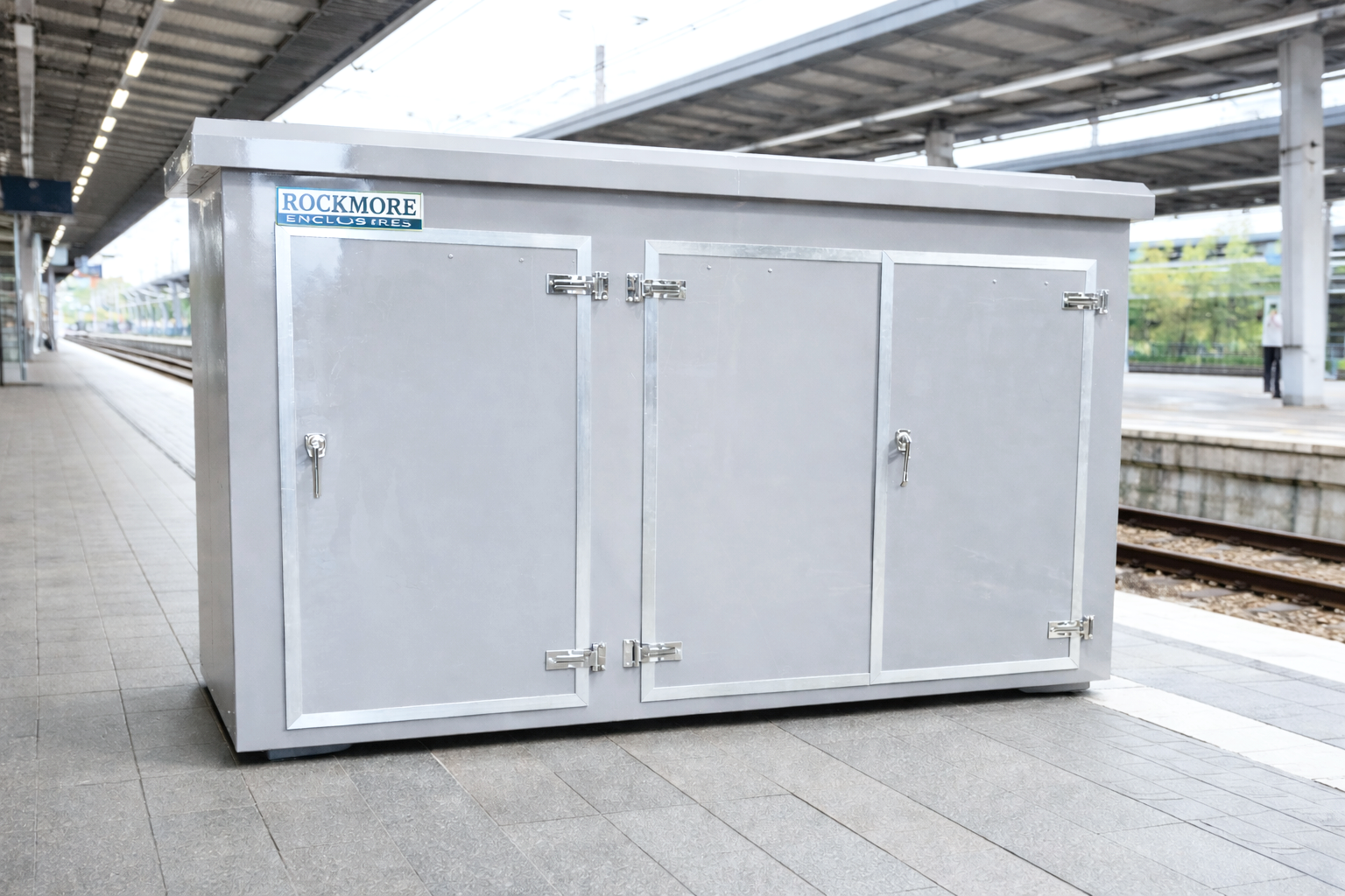 Silver metal storage box on a train platform at a train station.