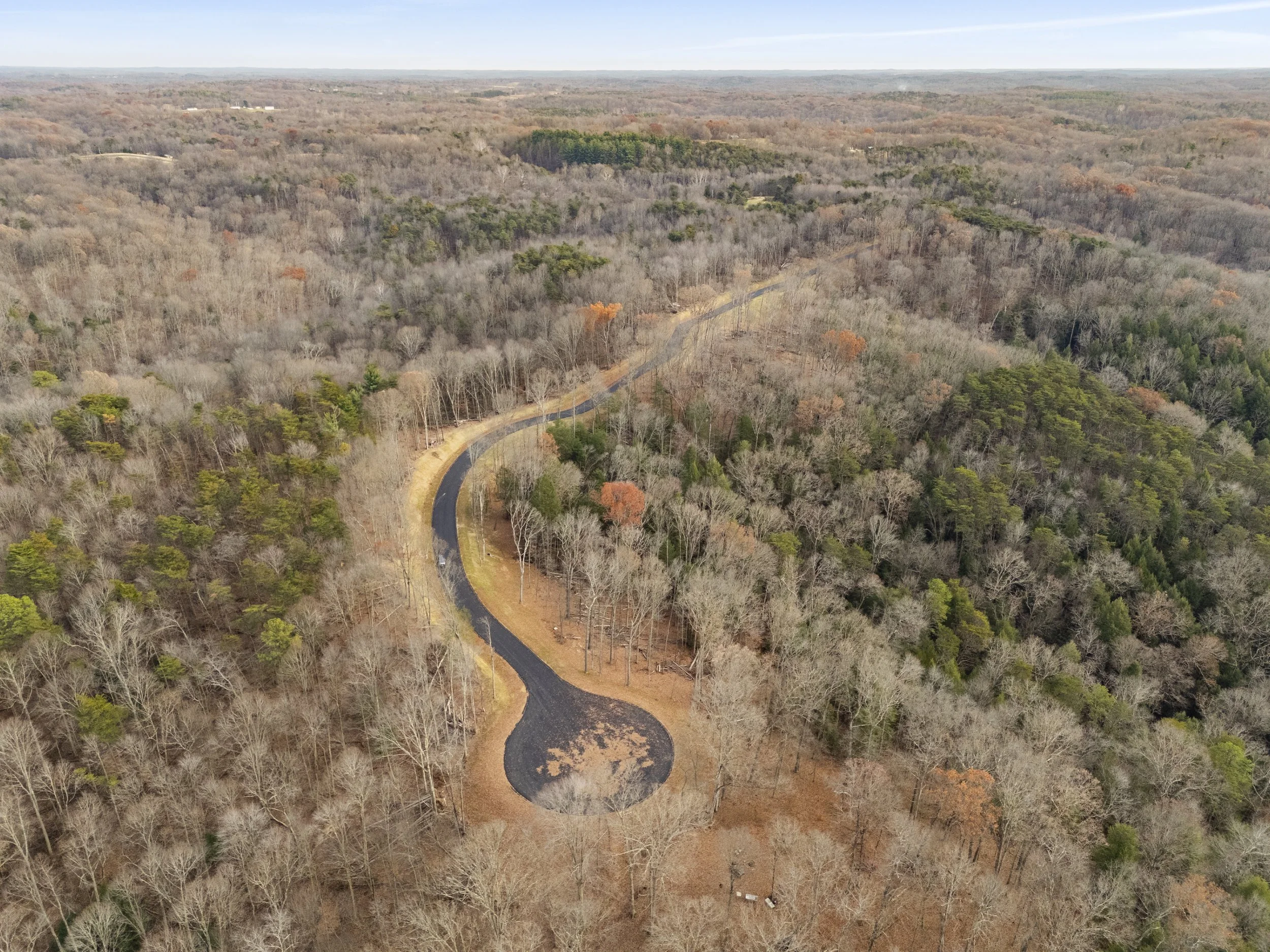 Modern kitchen with white island counter, gold faucet, copper cocktail glasses with lime and mint, and background shelves with plates, cups, and kitchen appliances.