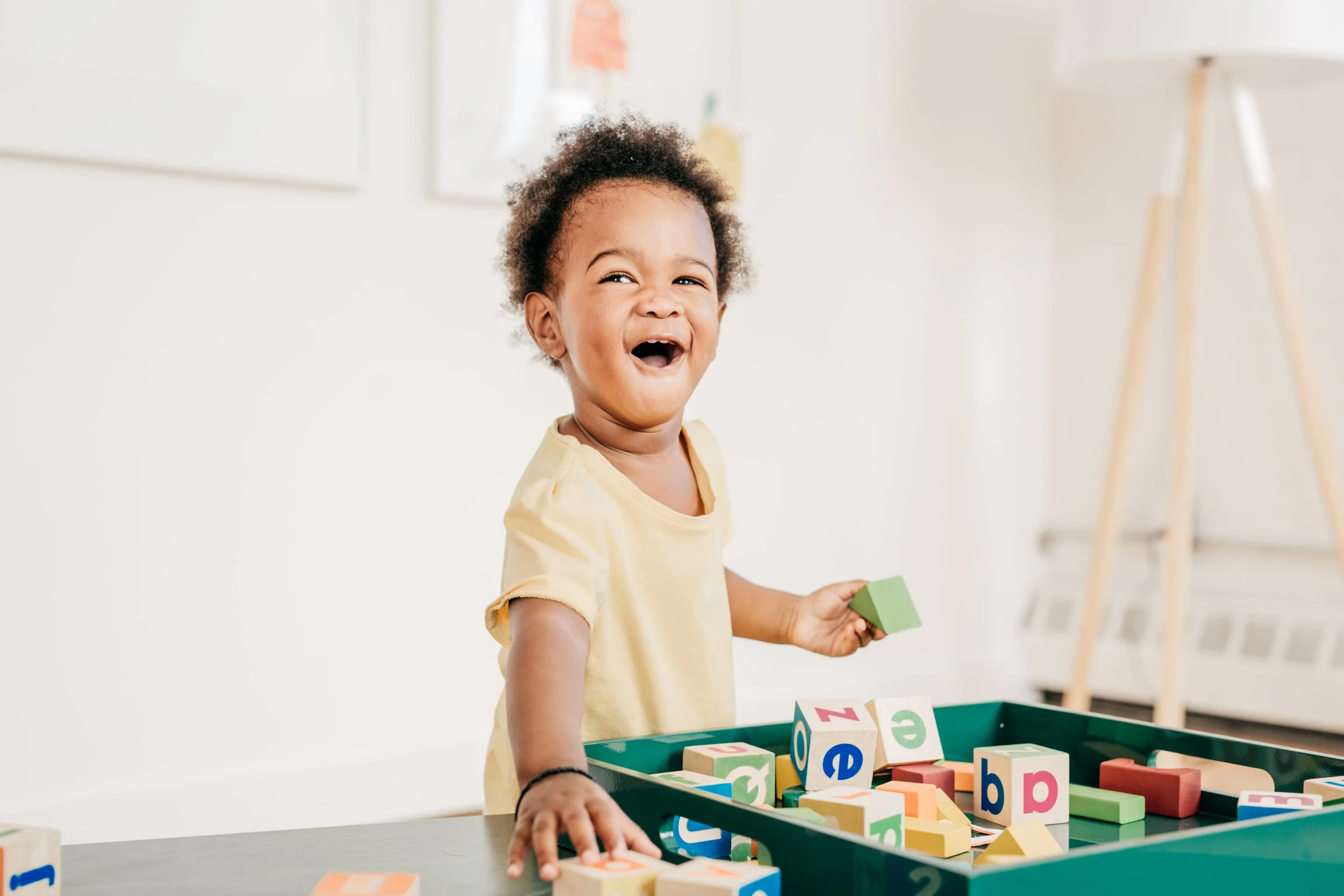happy little boy playing with blocks during aba therapy using NDBI and ESDM