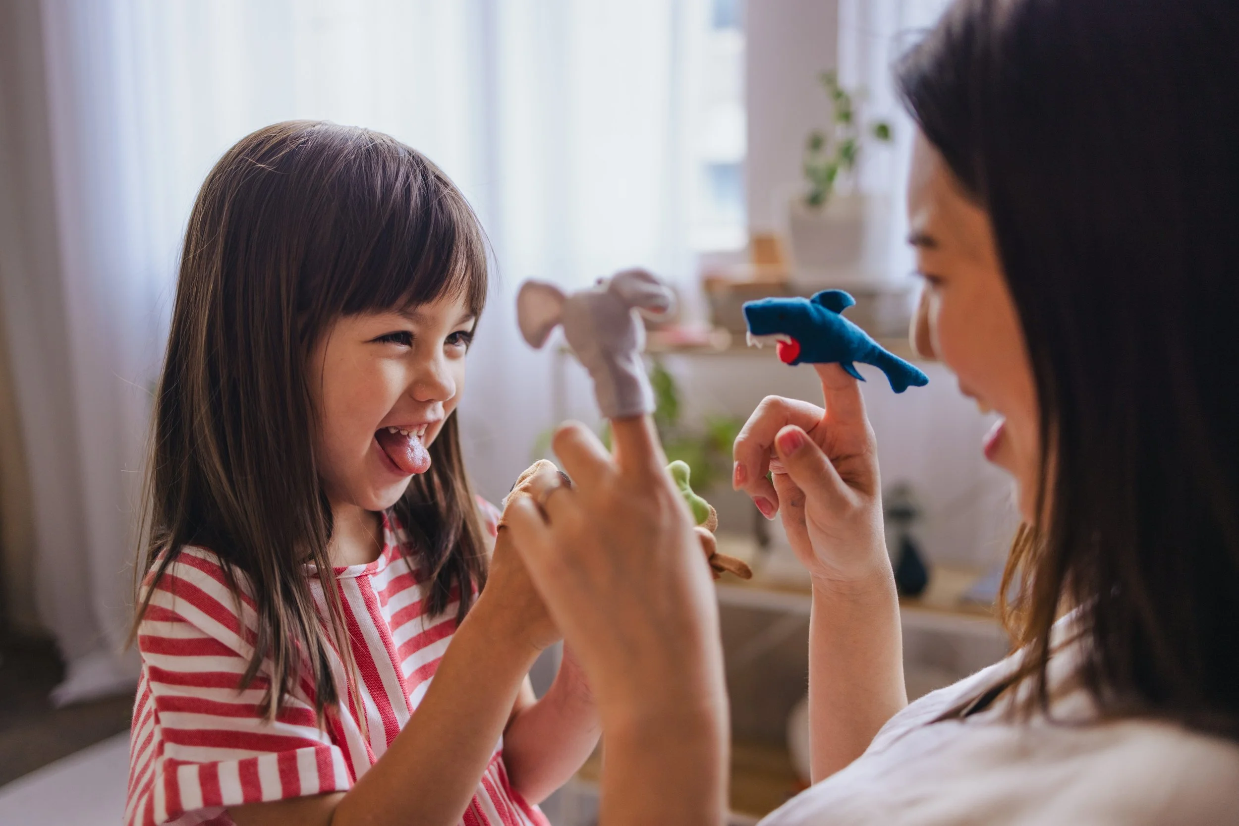 Adult and child playing with toys in their home