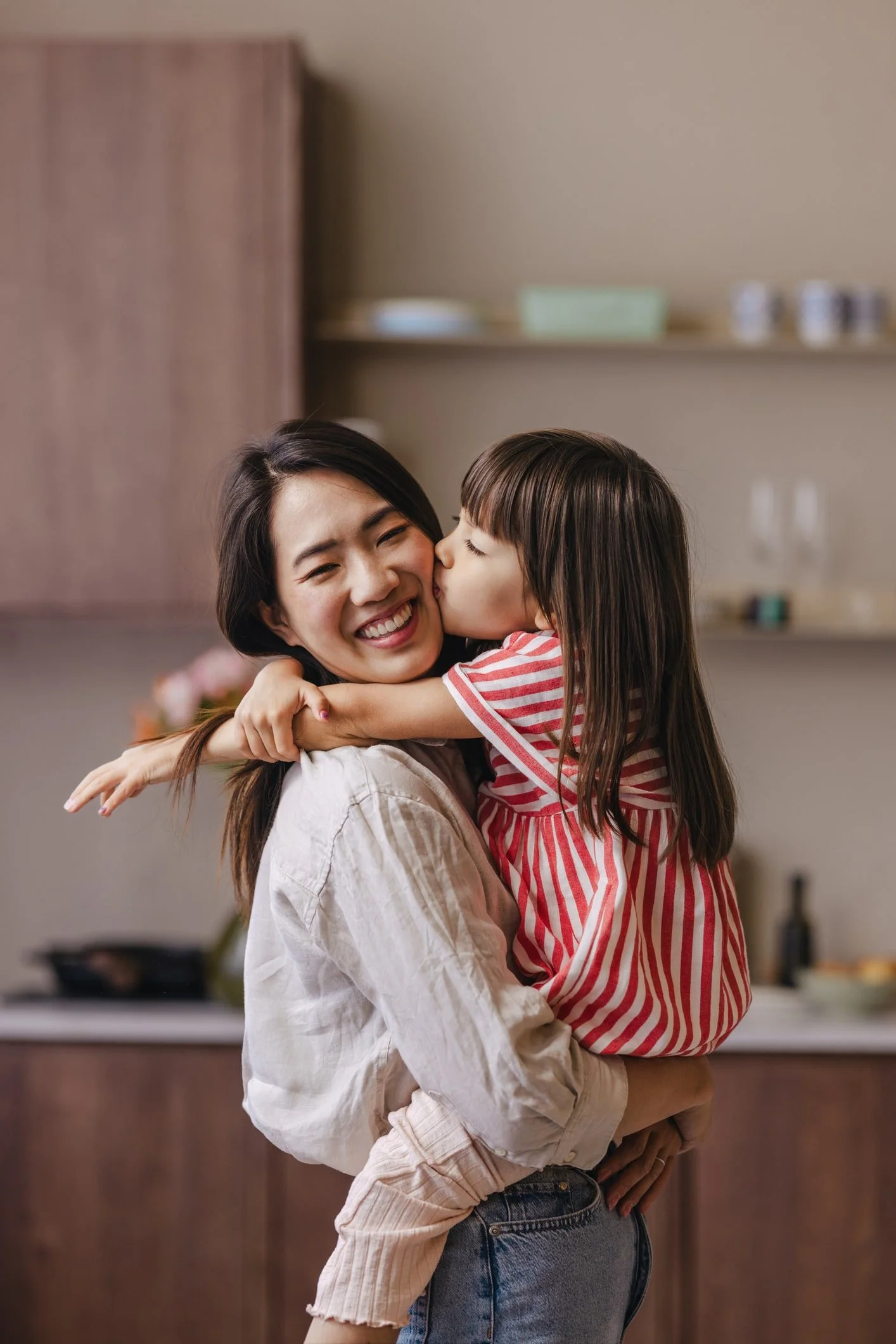 Mother hugging daughter happily