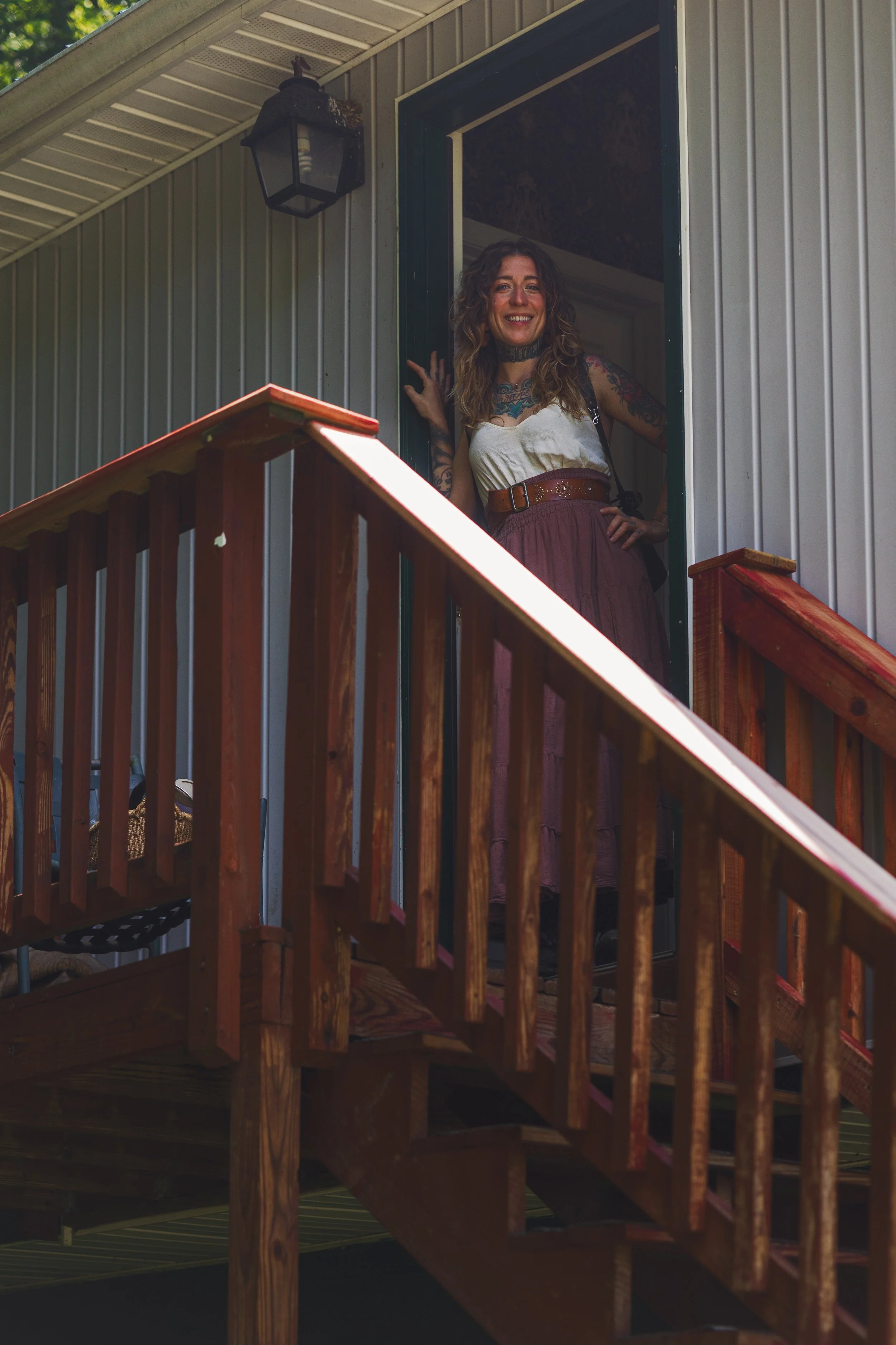 Treehouse Tattooer on steps of private treehouse Tattoo studio