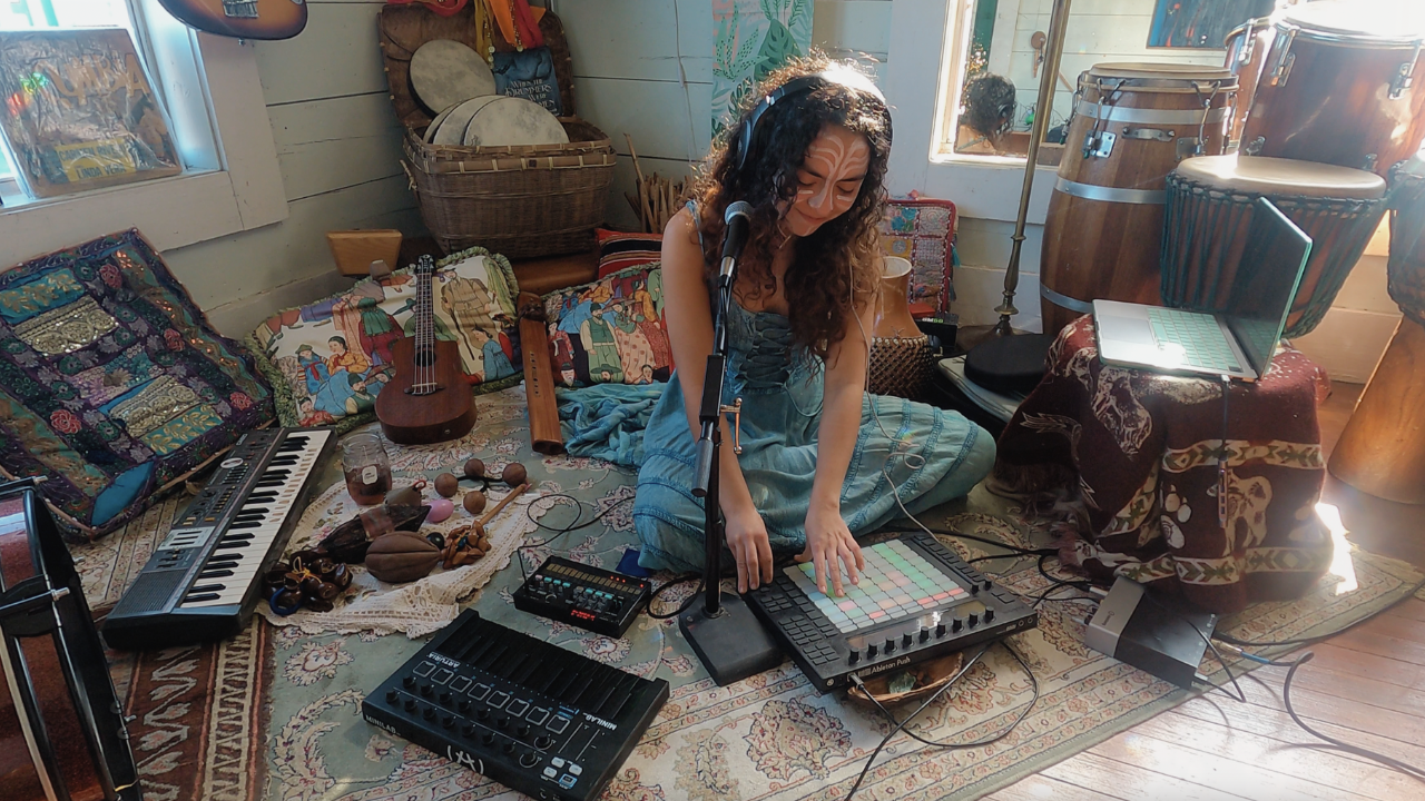 Music producer surrounded by instruments during home studio session at Delady DJ music retreat.