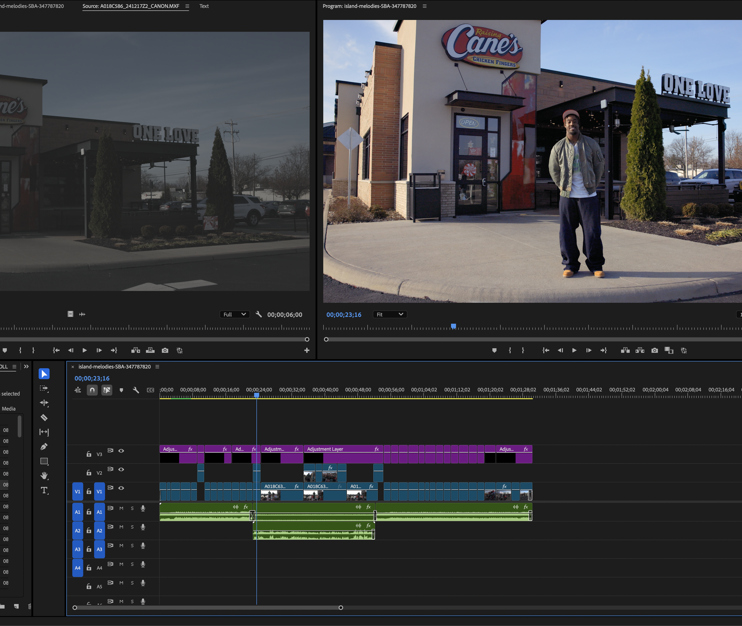 A man standing outside Raising Cane's chicken fingers restaurant with the restaurant's sign behind him and a car parked in the lot.