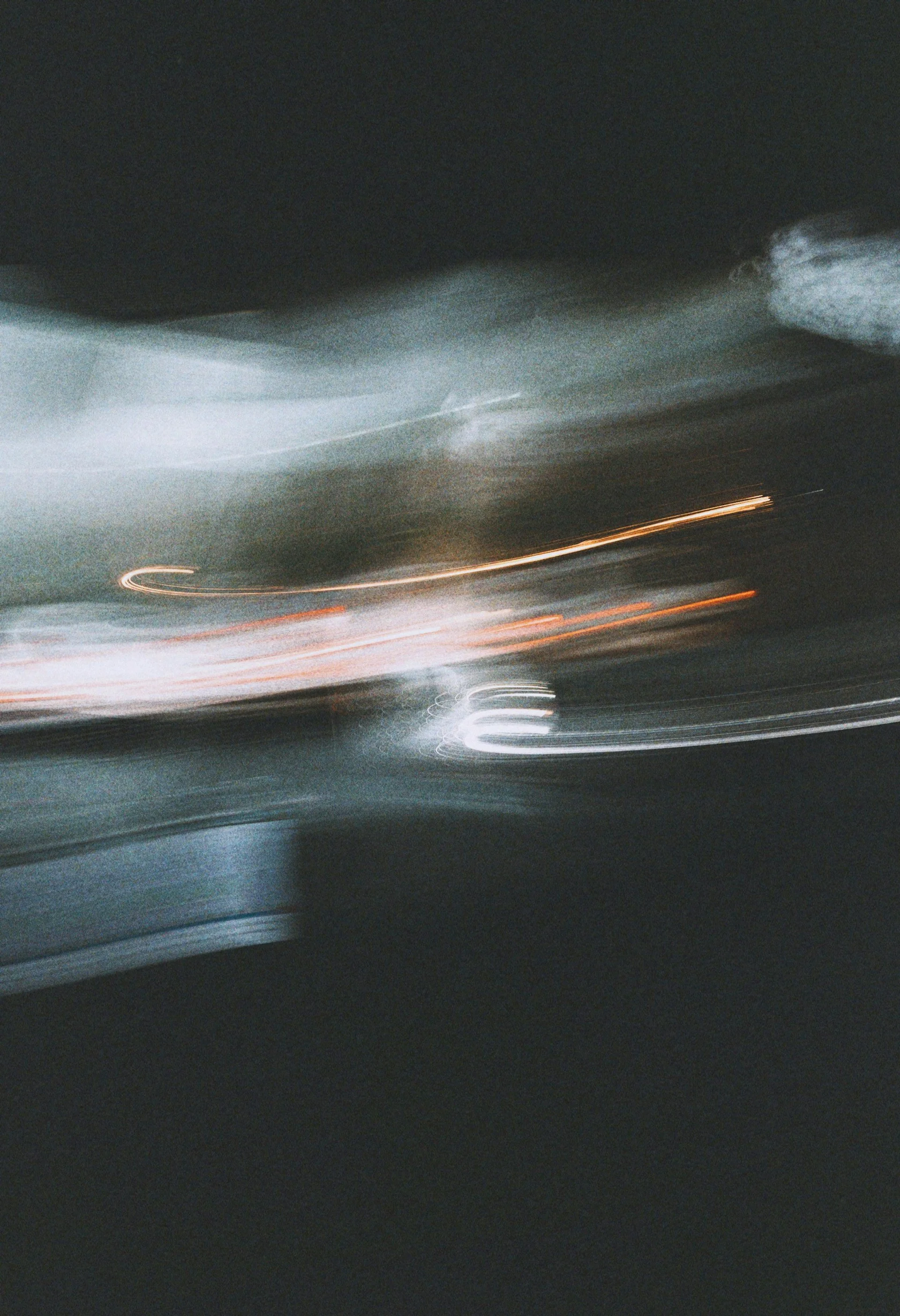 Blurred motion of city lights at night, showing streaks of light and dark sky.