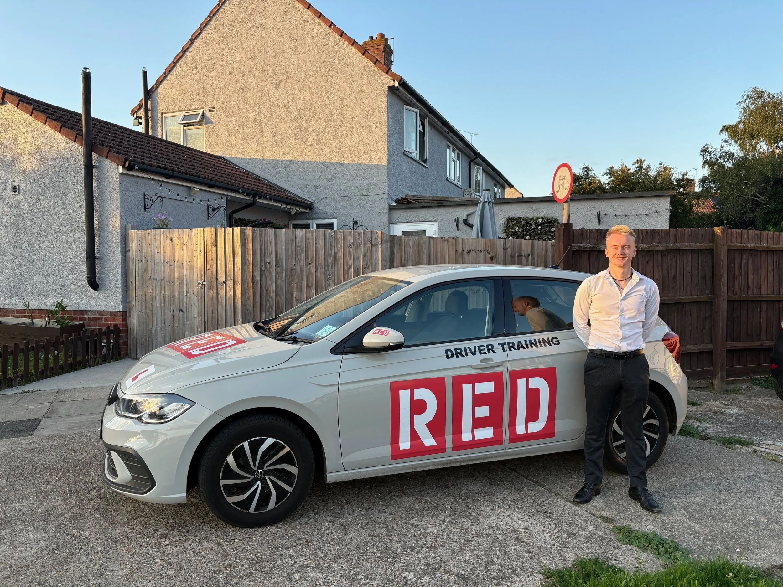 Thomas Horton standing in front of EM Driving School's learner driver car