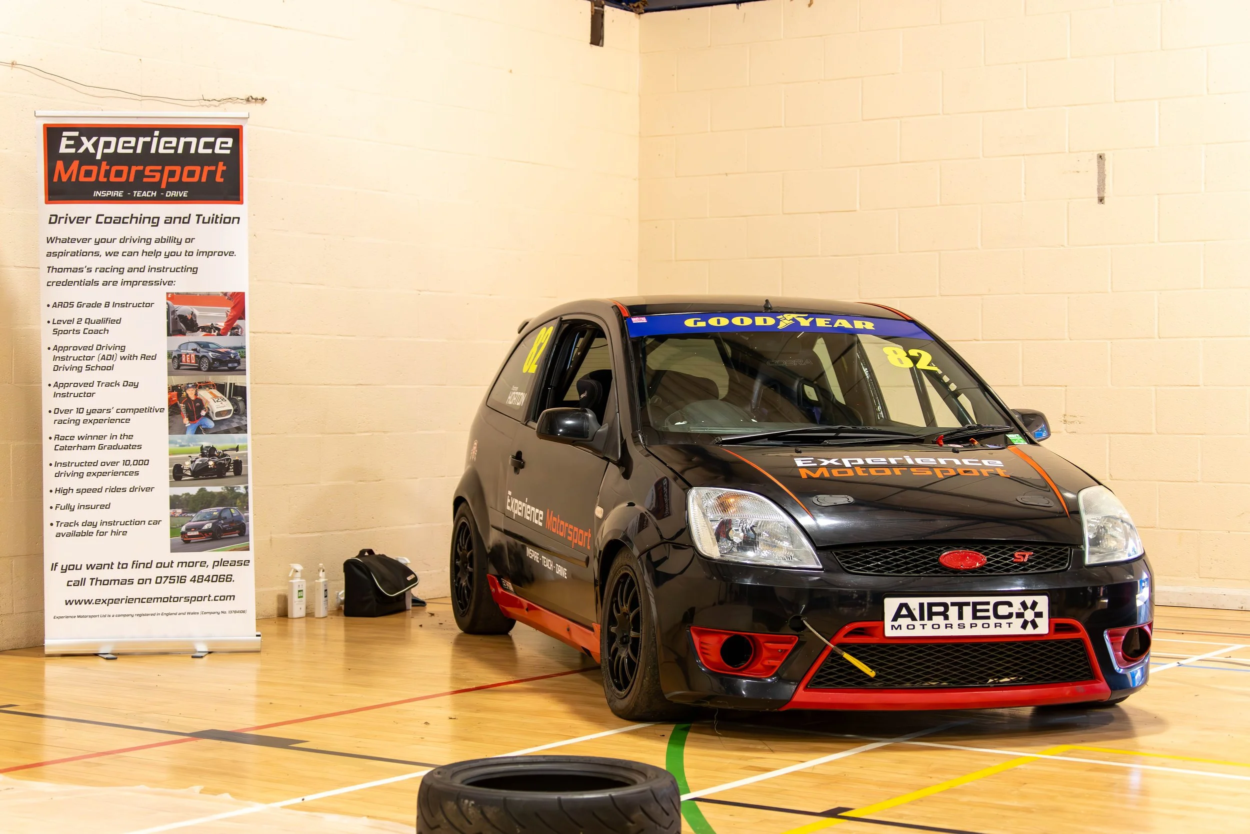 A branded Ford racing car with livery on it inside a gymnasium