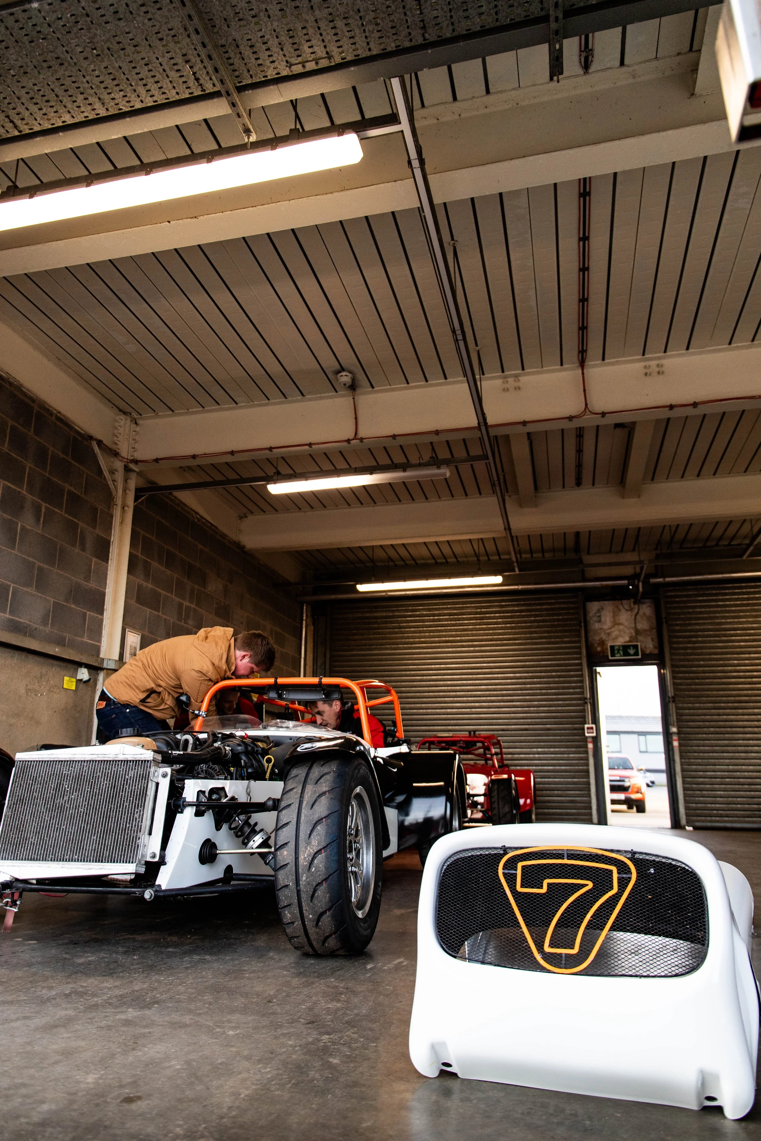 Caterham race car being worked on in a track-side garage