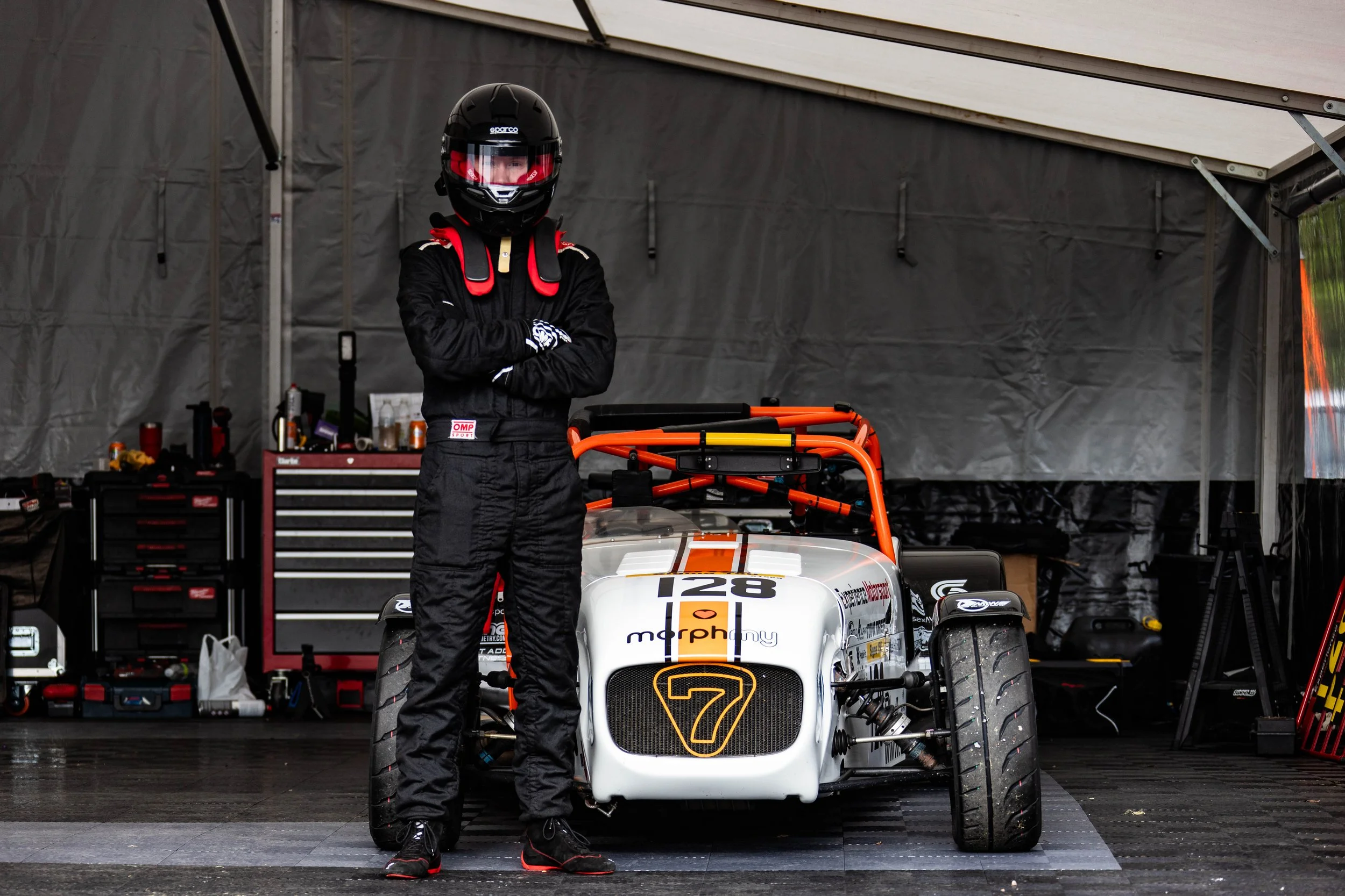 Thomas Horton standing in front of his Caterham race car geared up in his racing gear