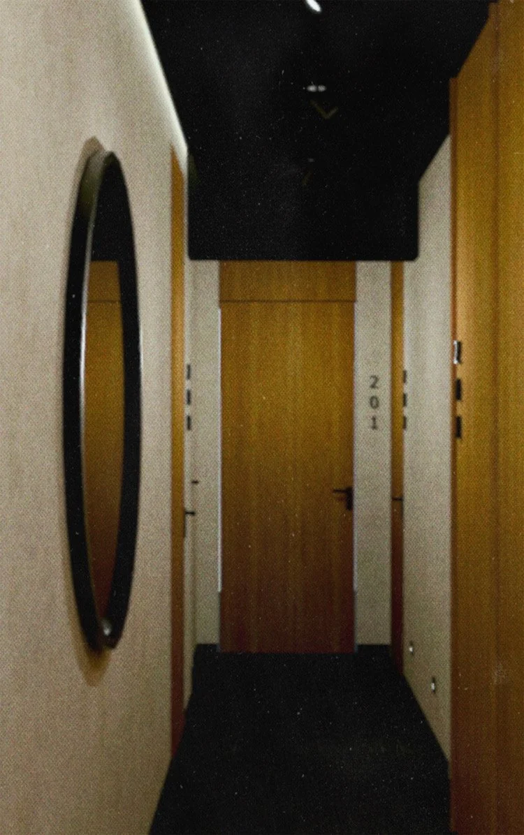 A narrow hallway with beige walls, a large round mirror on the left wall, dark ceiling, and wooden doors. There are lines of text on the right wall reading '2ND' and other markings.