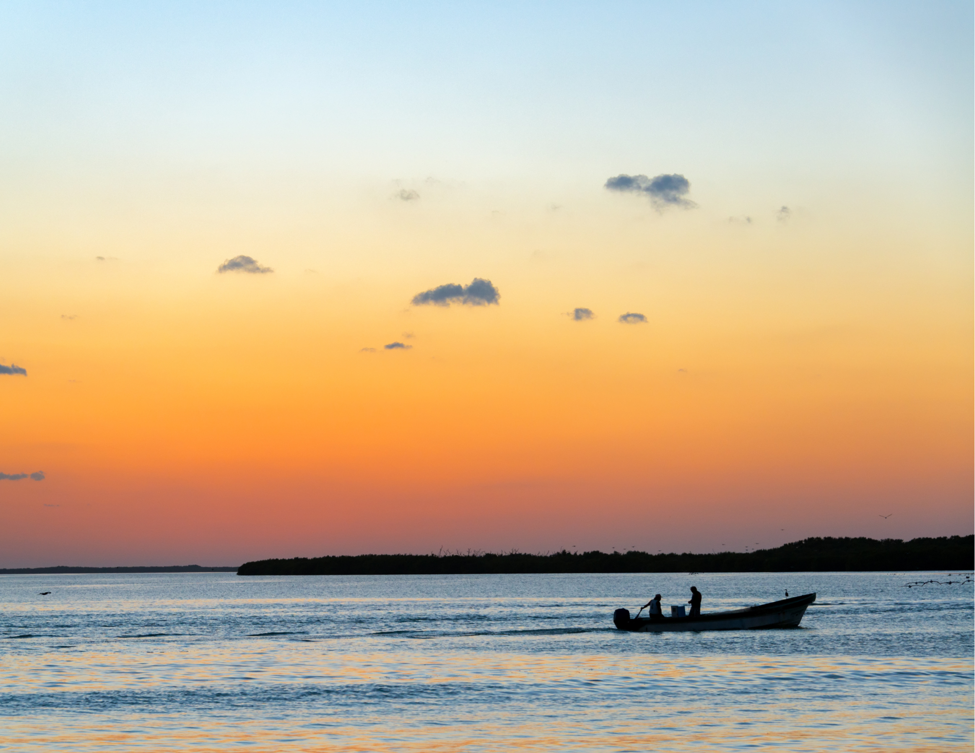 A boat with two people fishing in a Lake Ontario bay in Cape Vincent New York