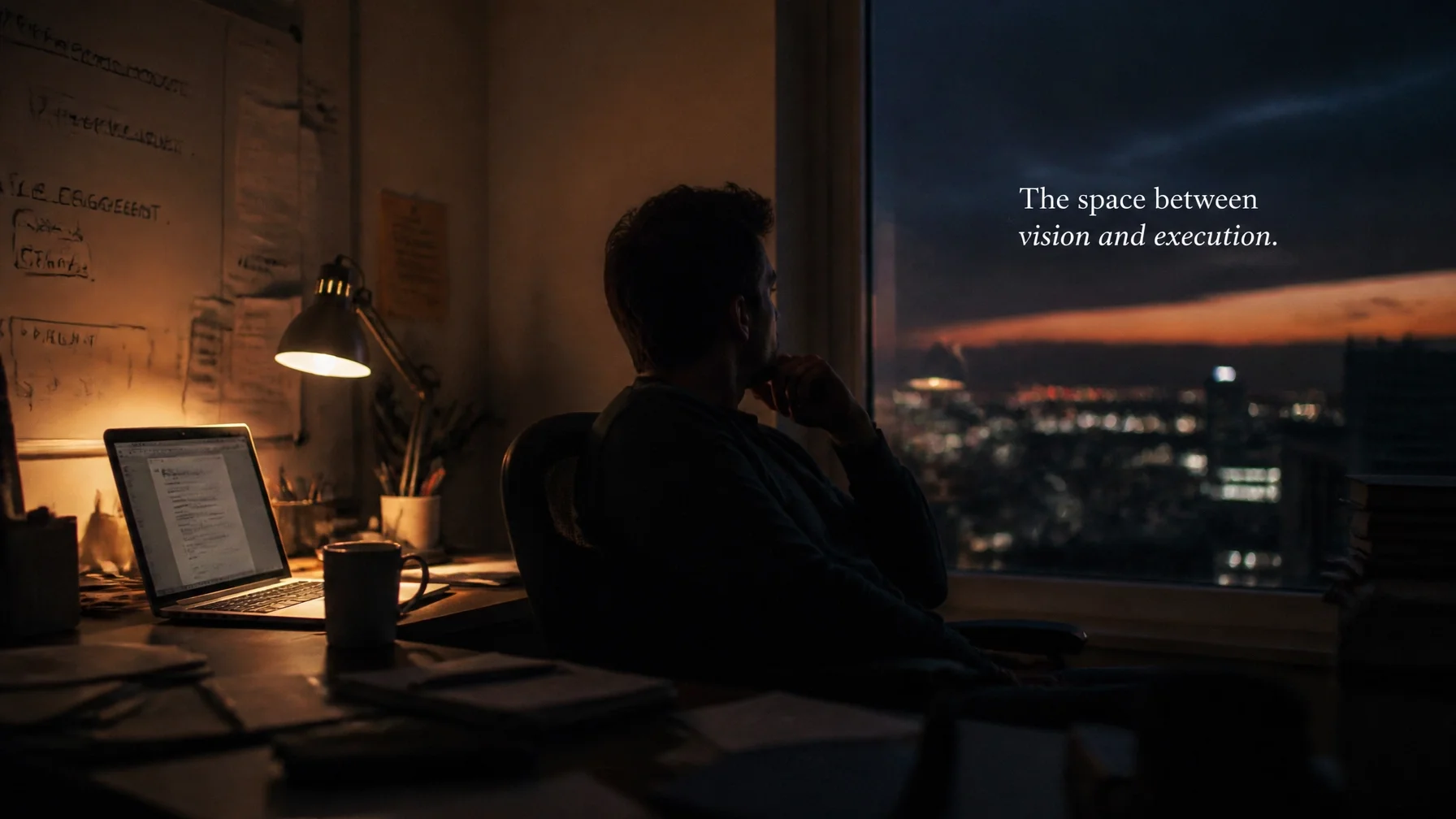 A tech startup founder in a moody, dimly lit workspace at dusk, looking thoughtfully out of a window. Text overlay: 'The space between vision and execution.'