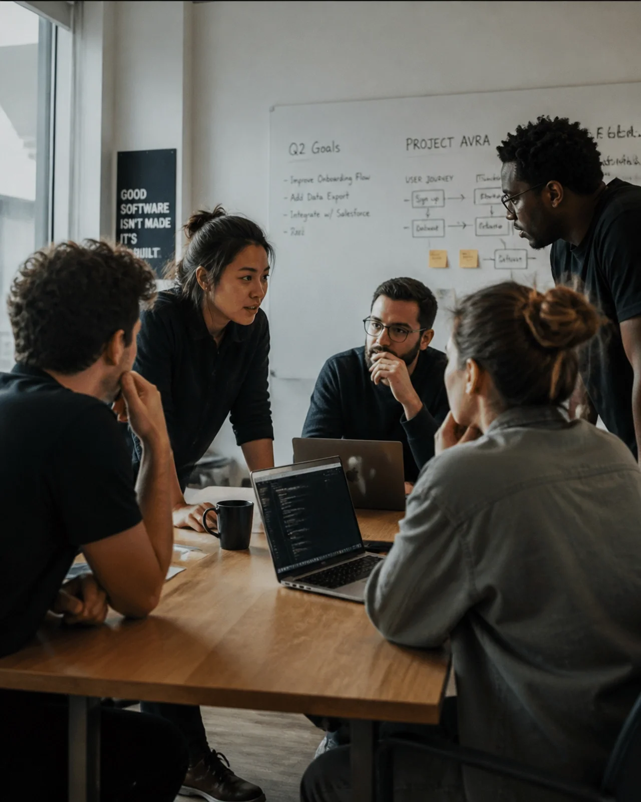 A software team in a focused, calm huddle around a table
