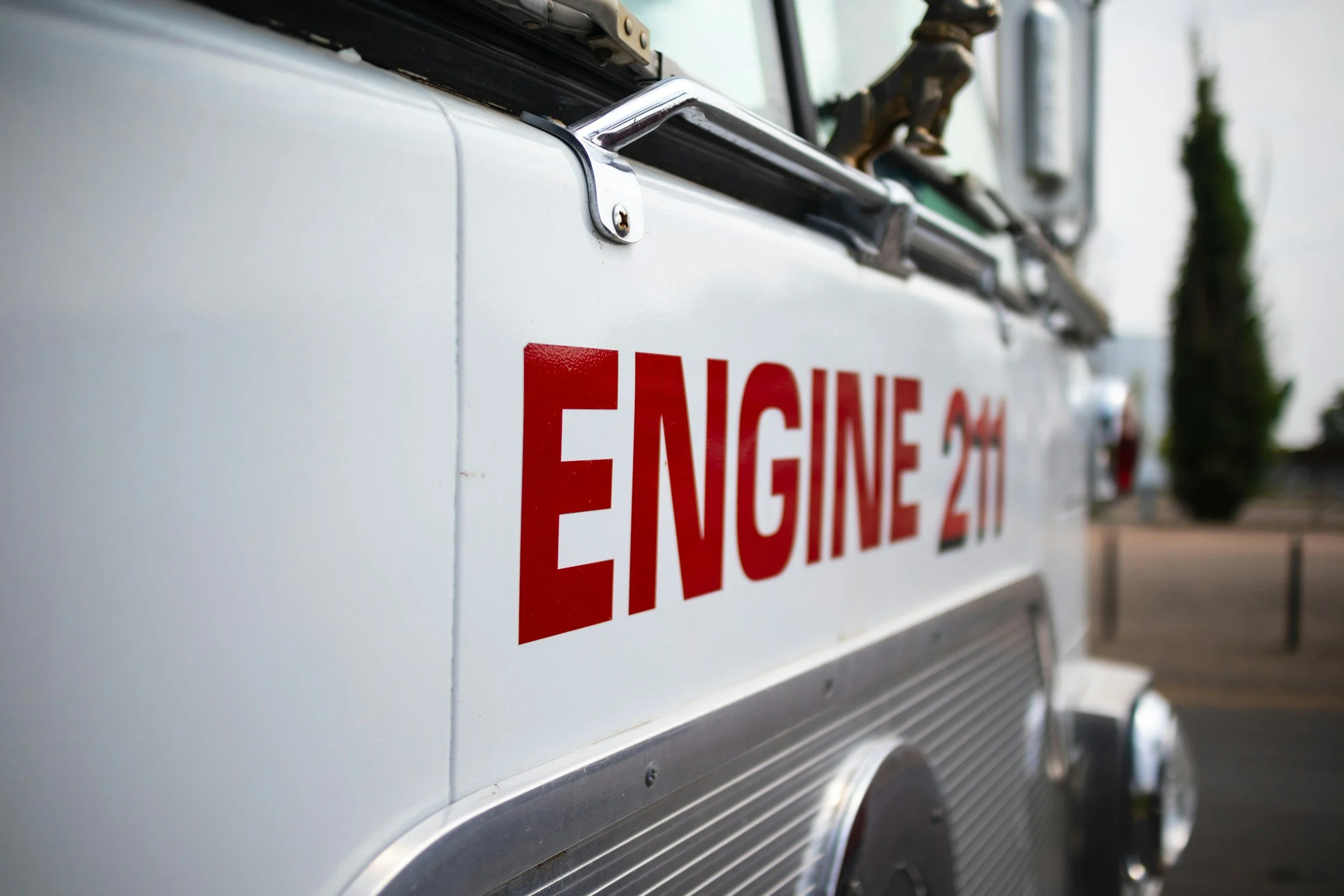 Close-up of a fire truck with red 'ENGINE 211' lettering on the side.