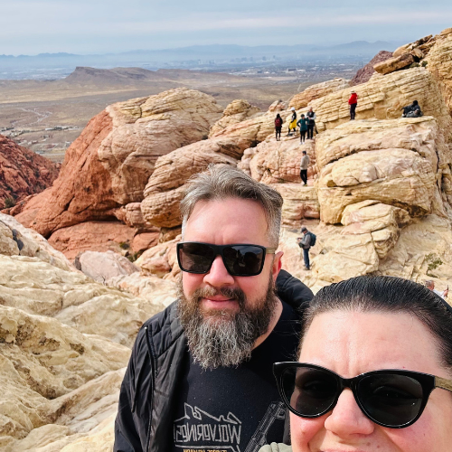 Couple taking a photo at Red Rock Canyon with scenic rock formations in the background