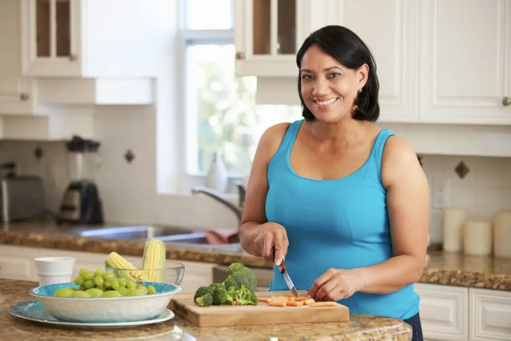 Woman preparing fresh vegetables in a kitchen before starting GLP-1 medication.