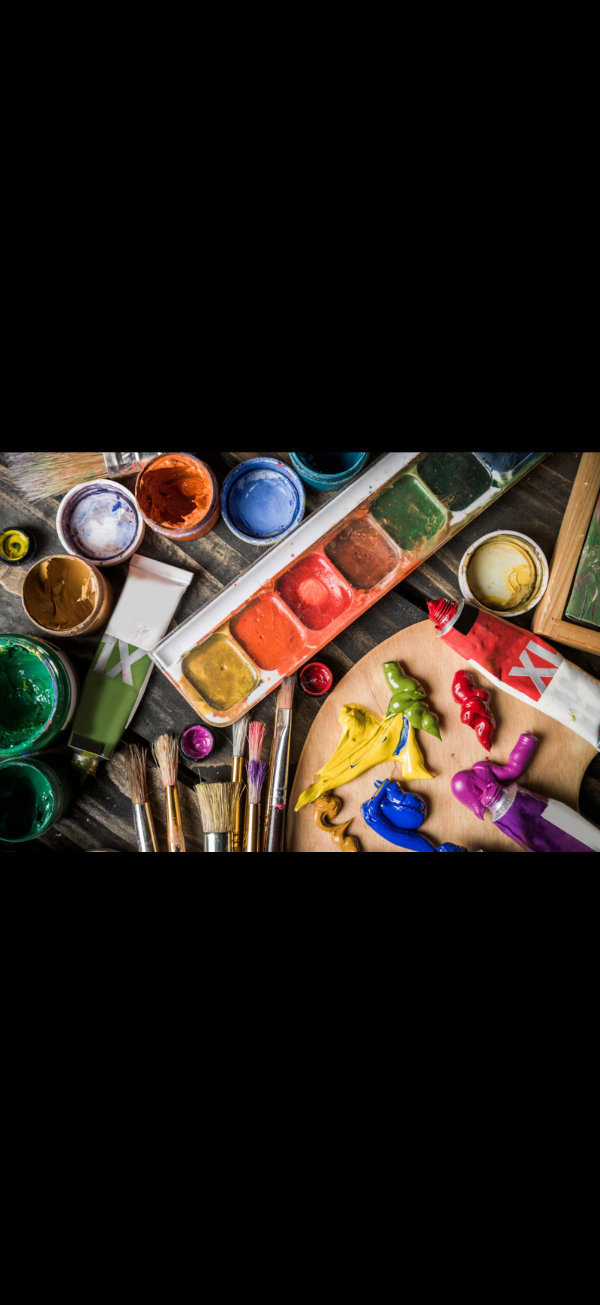 Paint supplies including open and closed watercolor paint jars, brushes, and tubes of colorful paint scattered on a wooden surface.