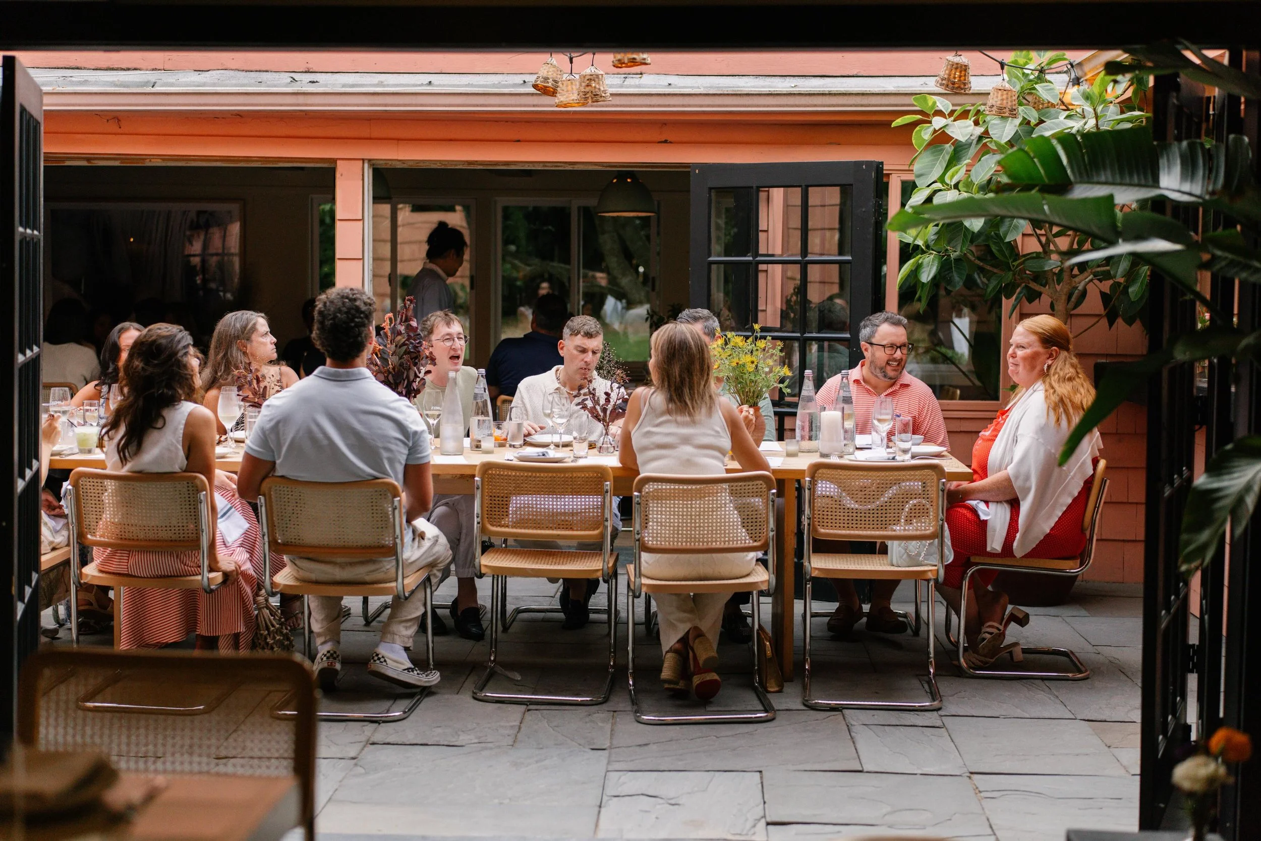 Guests enjoying a long outdoor dinner table at a private Italian catering event in New York City.