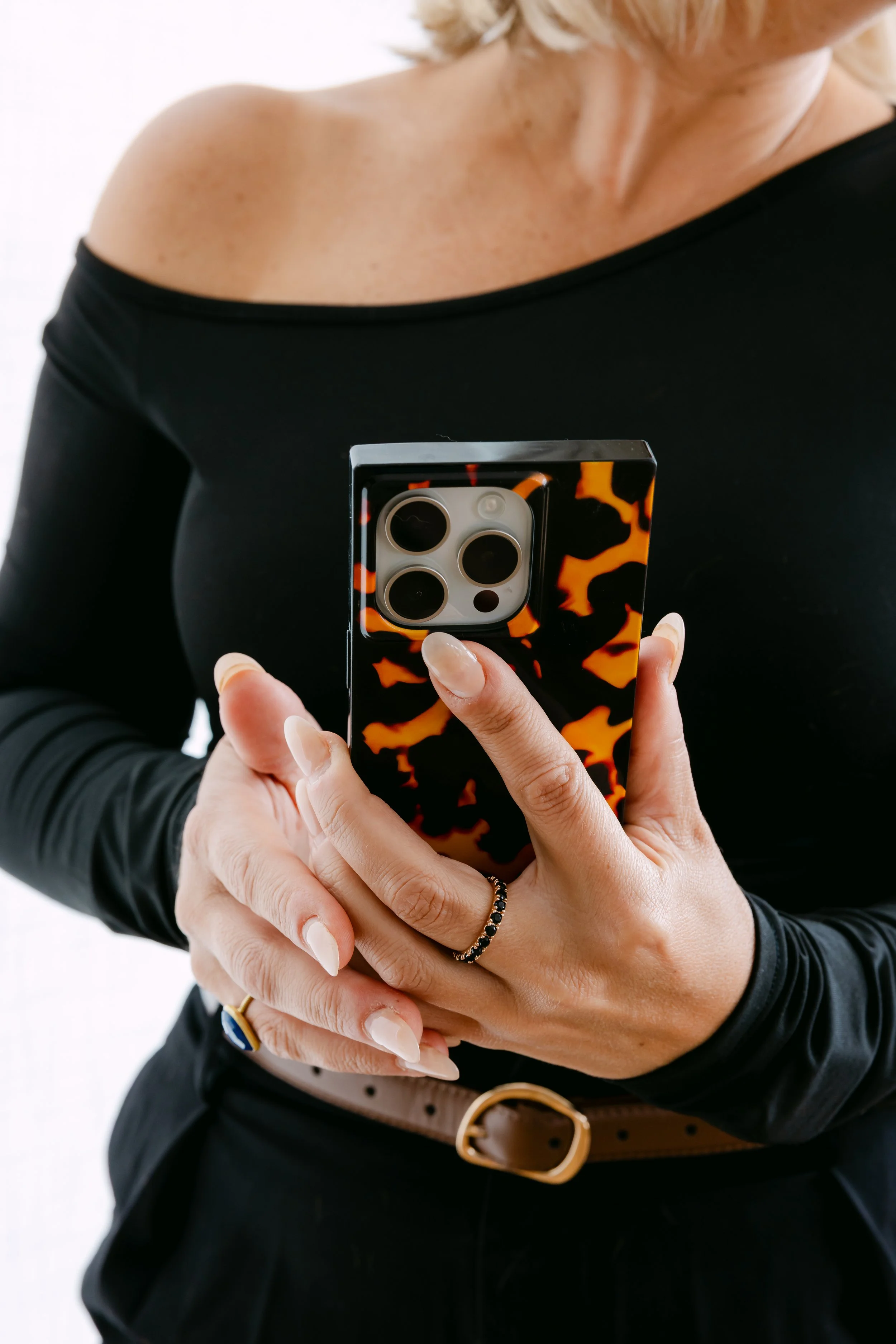 Person holding a Nikon F50 film camera, with a hand featuring a blue gemstone ring.
