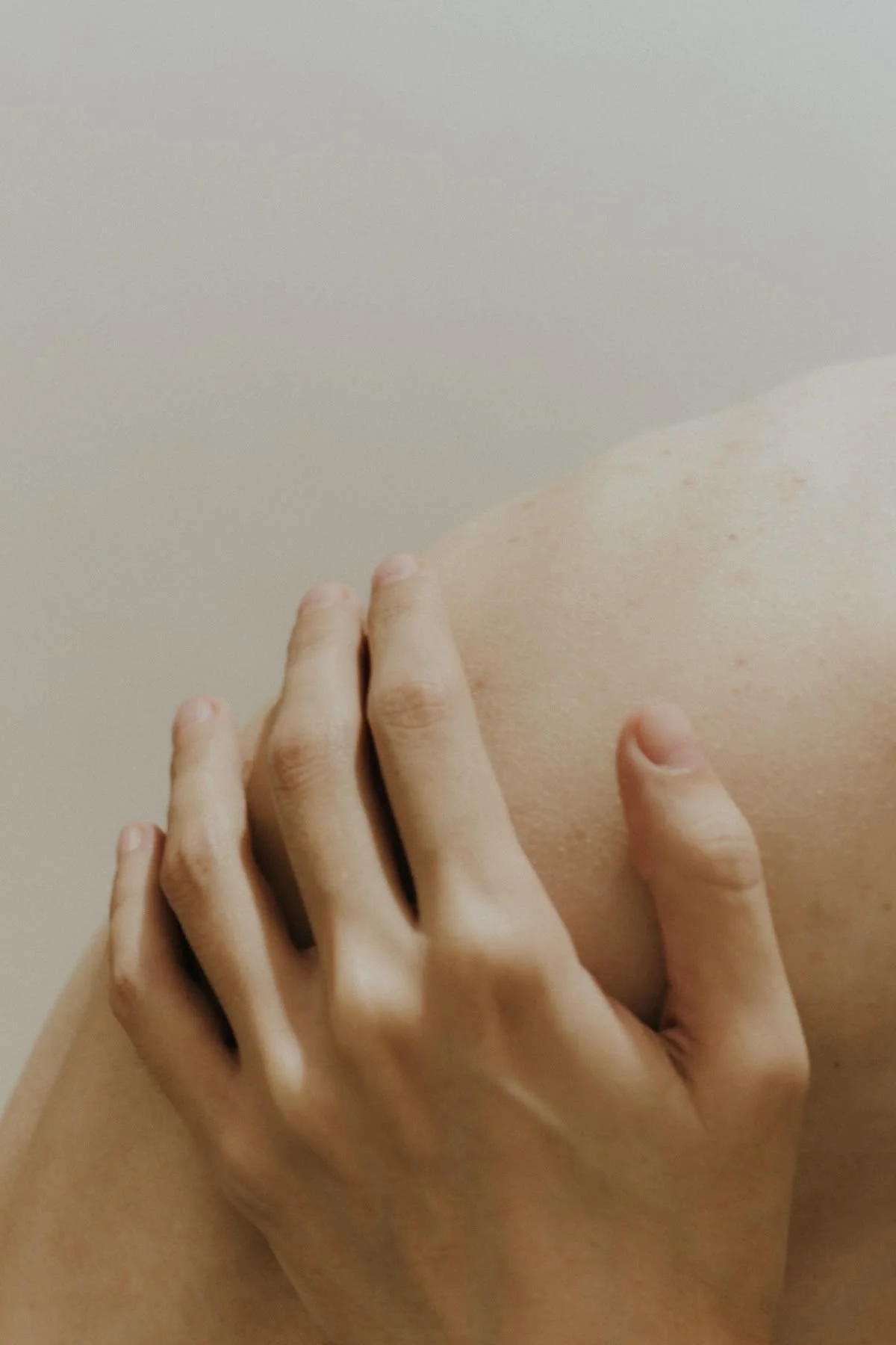 Nahaufnahme einer Hand, die auf eine menschliche Schulter oder Rücken greift.