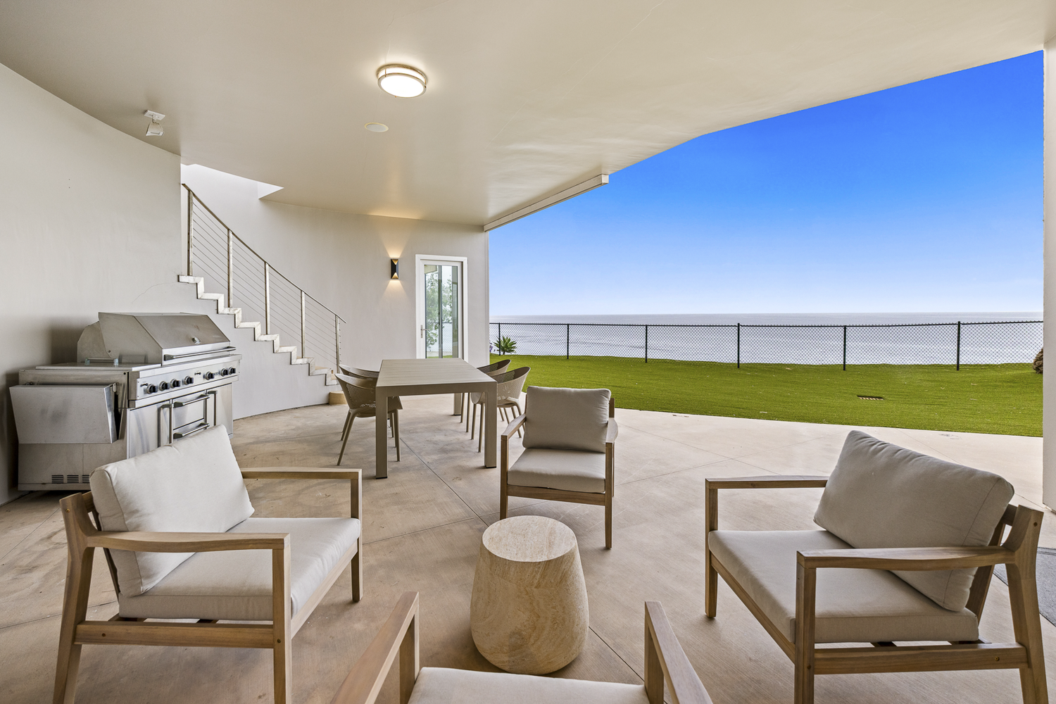 Covered outdoor seating and dining area overlooking the coast