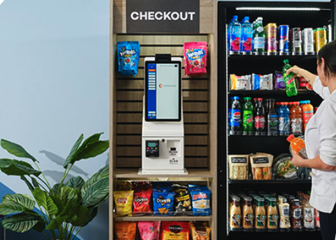 Self-checkout station with snack chips and beverages in a vending area.