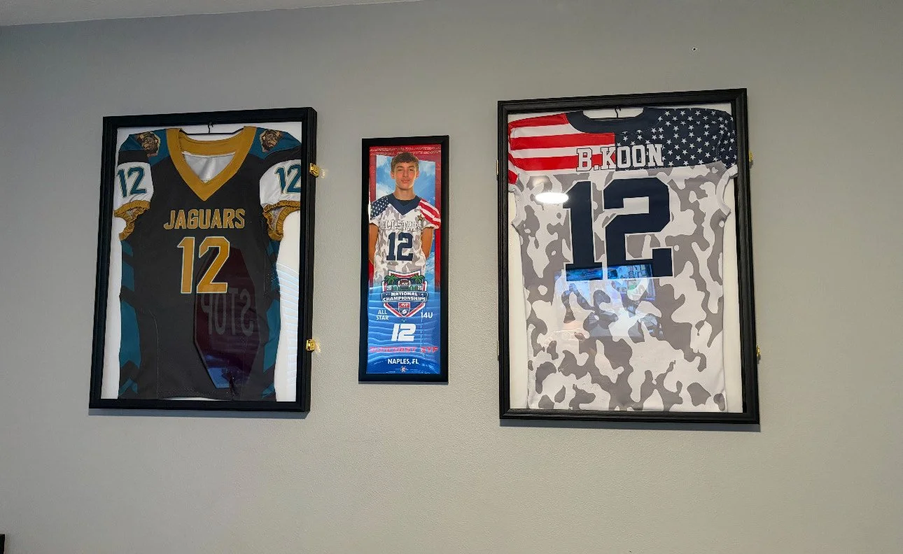 Wall display with framed football jerseys and photos for player number 12.