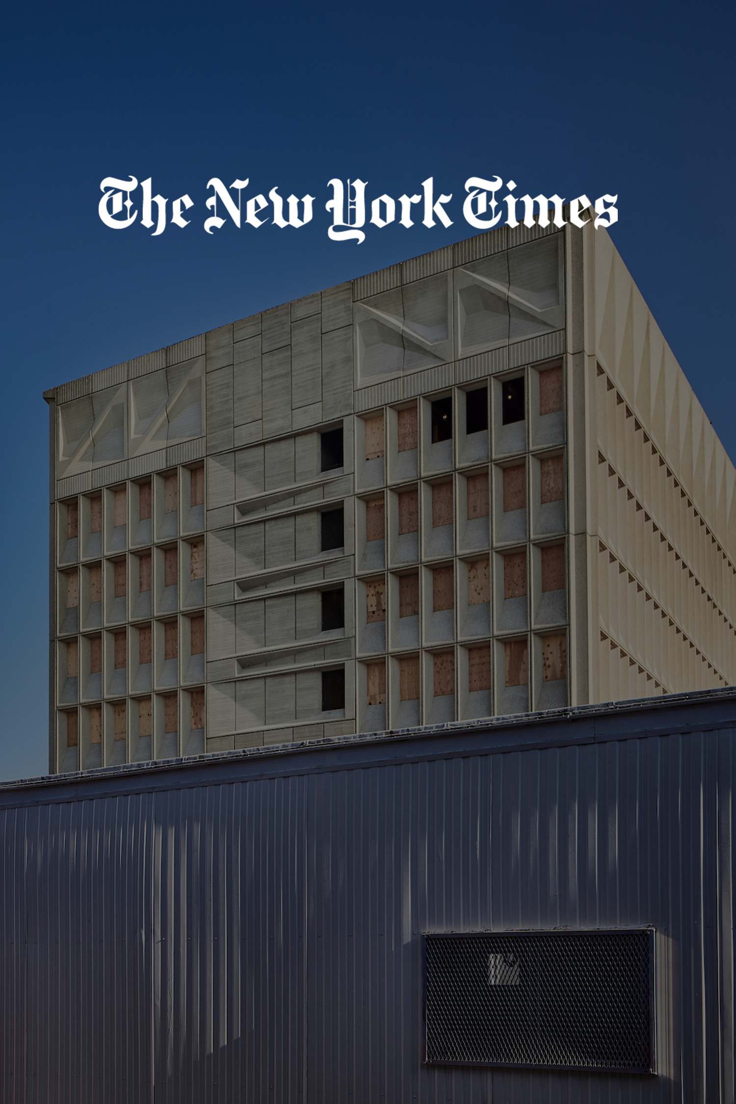 Cover of The New York Times with an image of a tall, modern building with a blue sky background.