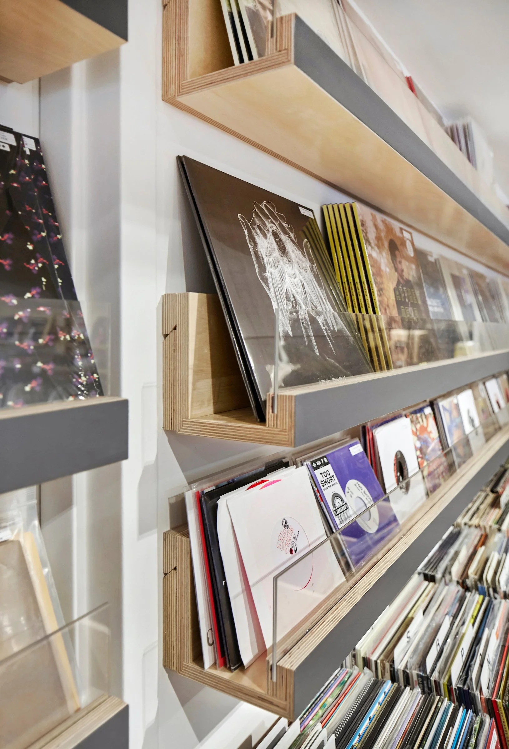 A bookstore shelf with vinyl records and magazines displayed.