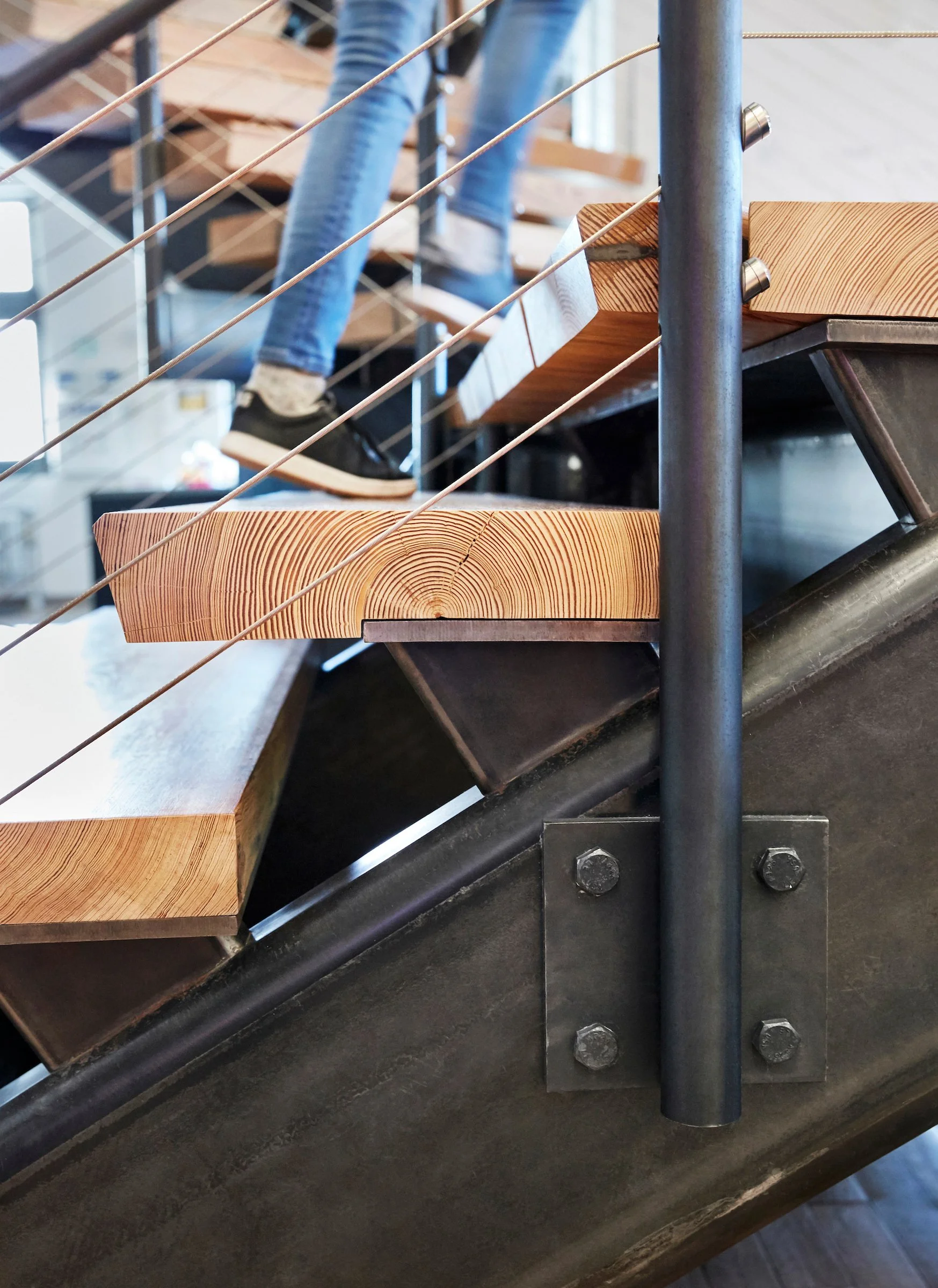 Close-up of a metal staircase with wooden steps and a safety railing.