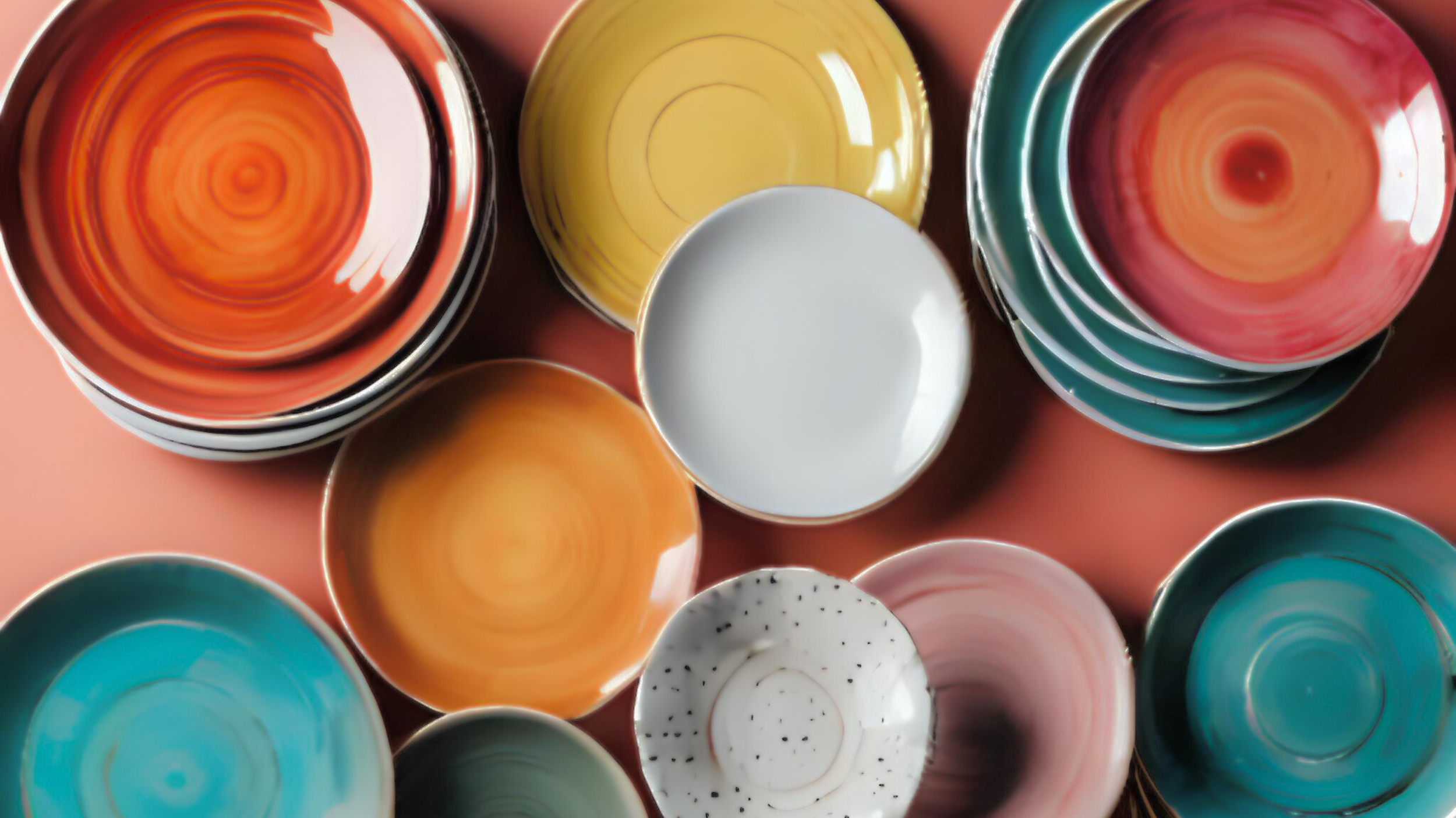 Top-down view of colorful ceramic bowls arranged in a cluster, with various bright colors and patterns.