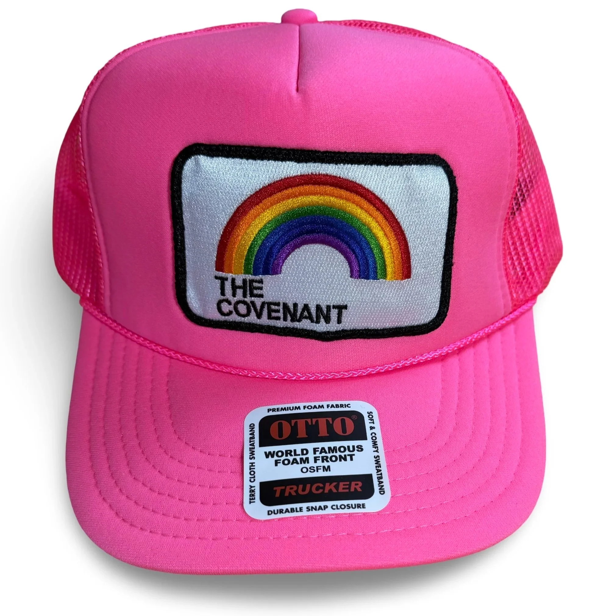 Pink trucker hat with a rainbow patch and the words 'The Covenant' on it.