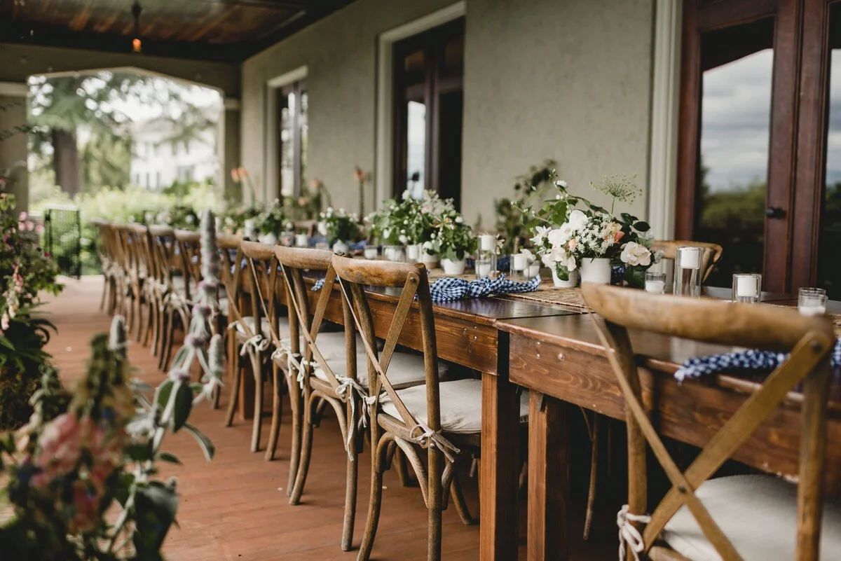 Outdoor table decorated with flowers and candles for a gathering or celebration.