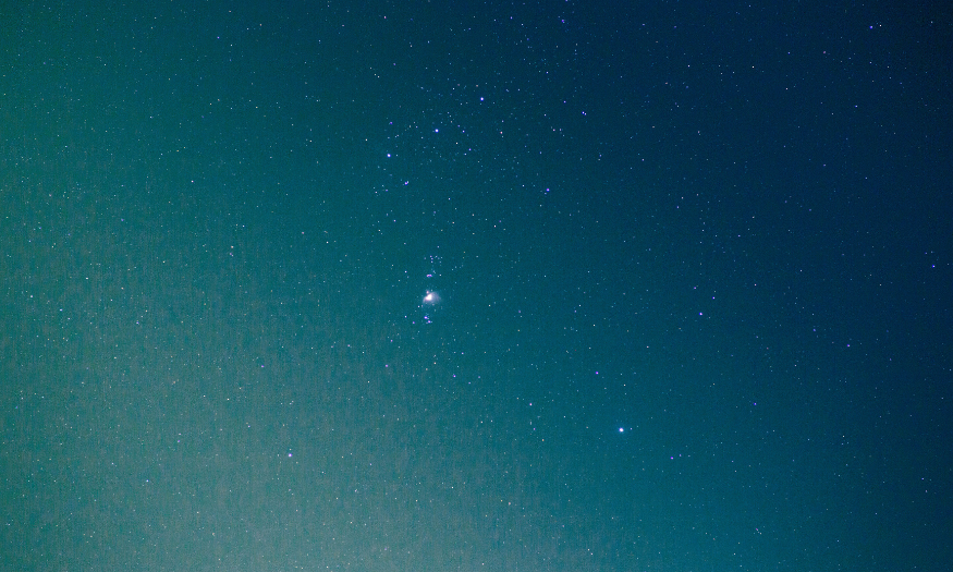 Night sky filled with numerous stars and a constellation cluster.