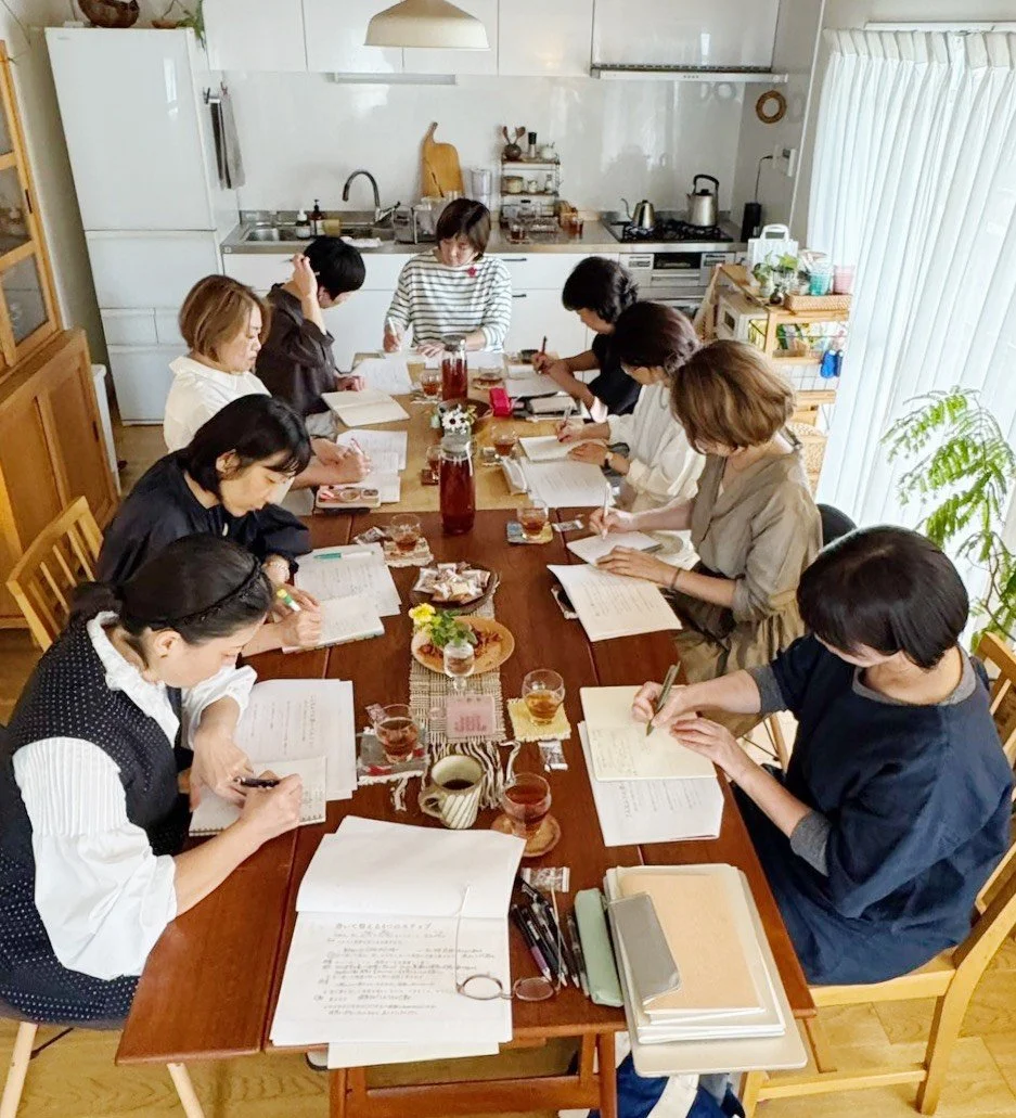 キッチンのテーブルで会議をしている十人の女性たち