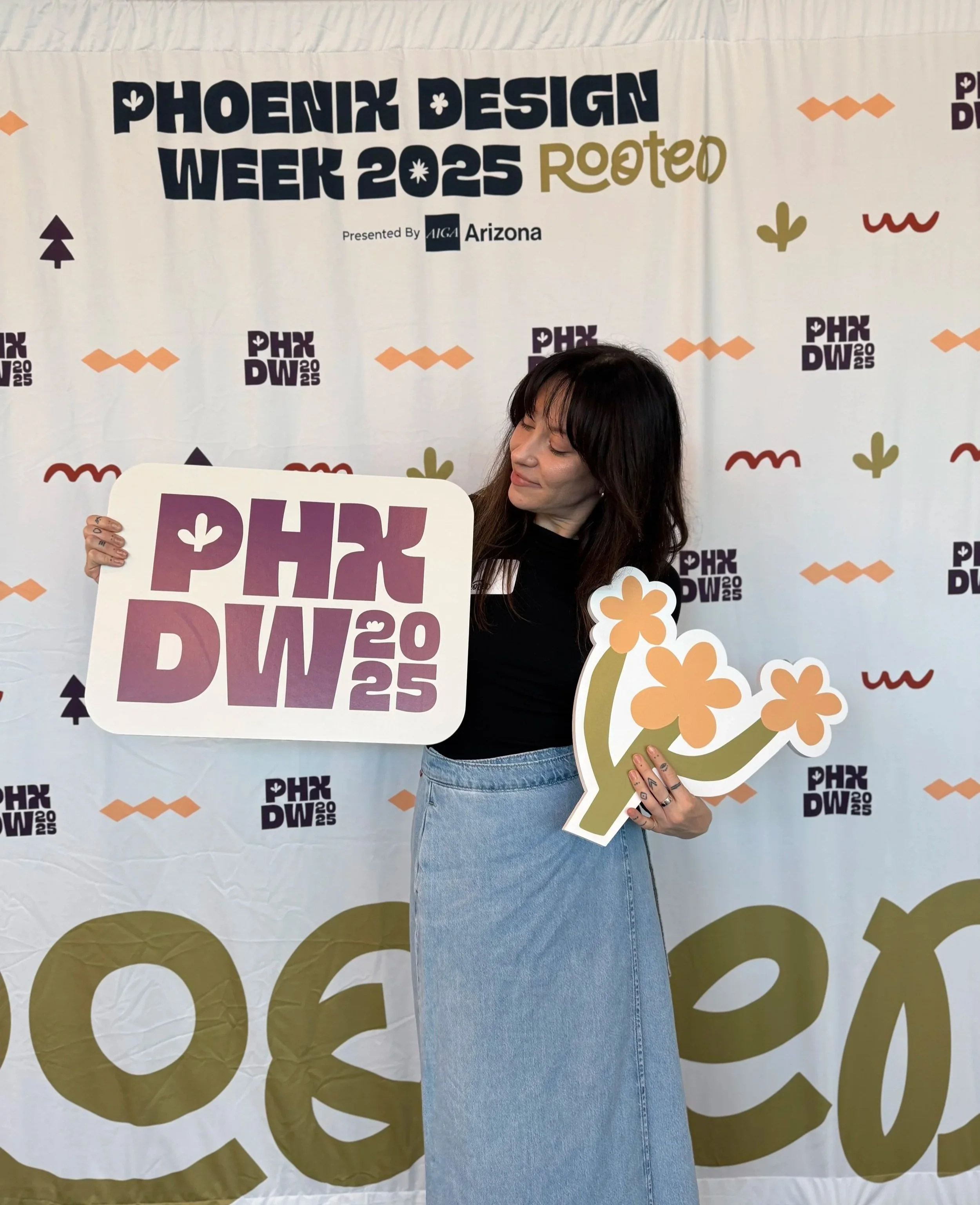 Taylor Hammes posing with Phoenix Design Week 2025 signage in front of the event’s branded backdrop.